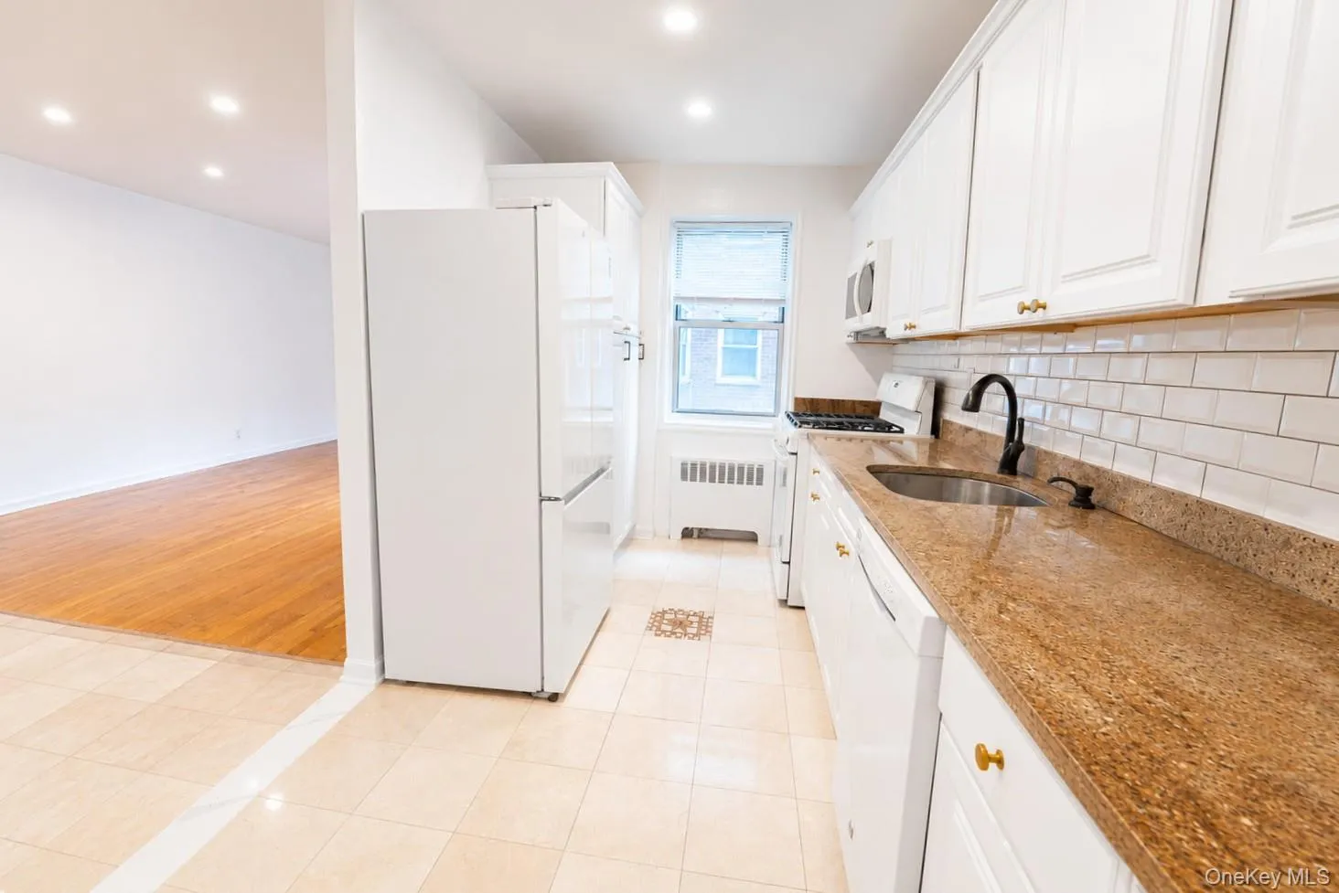 Recessed lighting and a kitchen window provide a bright, inviting atmosphere with plenty of natural light. Recessed lighting and a kitchen window provide a bright, inviting atmosphere with plenty of natural light.