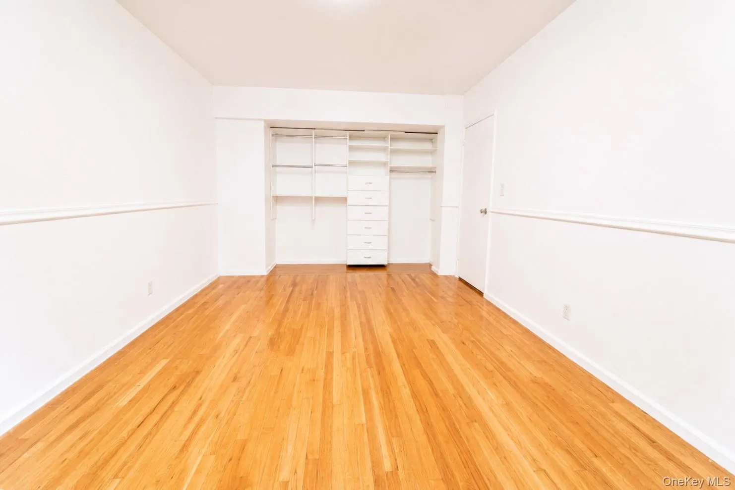 The bedroom includes a generously sized closet with a custom organizer, making storage both convenient and efficient. The bedroom includes a generously sized closet with a custom organizer, making storage both convenient and efficient.