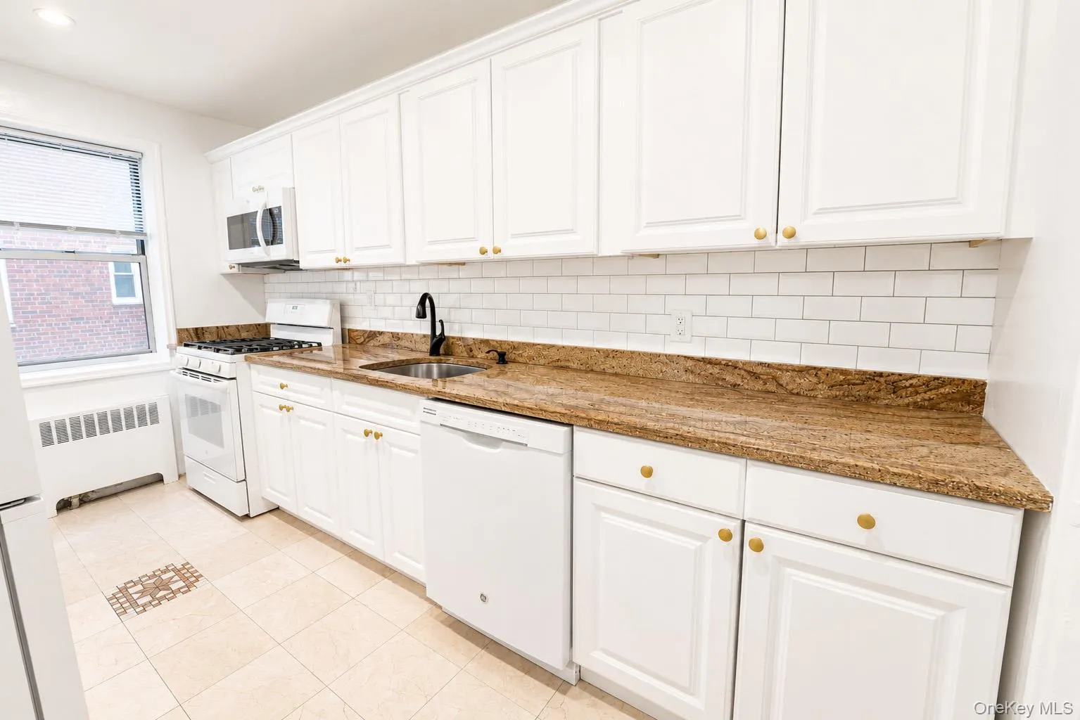 The kitchen features white kitchen cabinets, granite countertops and plenty of storage. The kitchen features white kitchen cabinets, granite countertops and plenty of storage.