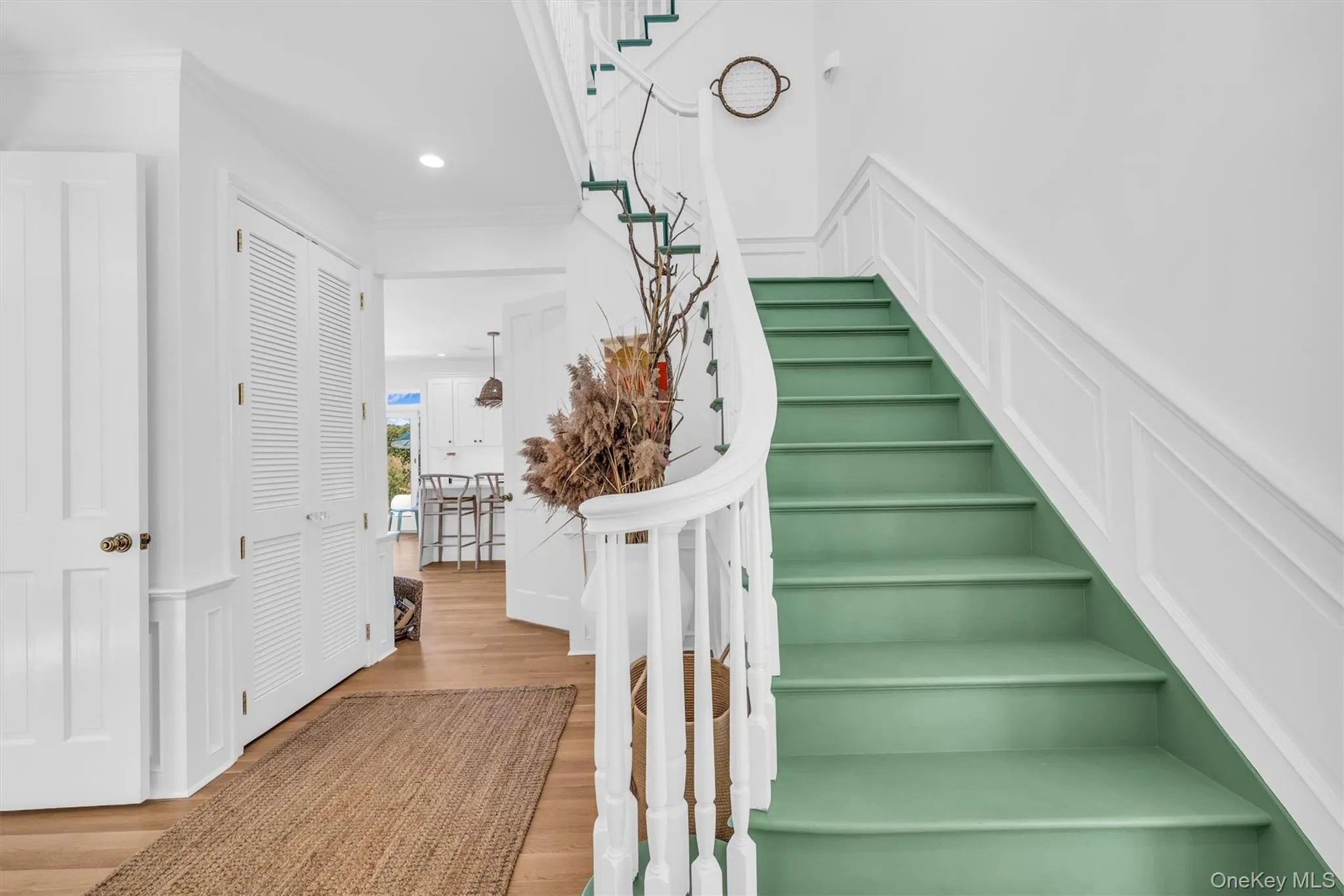Grand staircase featuring white balusters and a curved handrail Grand staircase featuring white balusters and a curved handrail