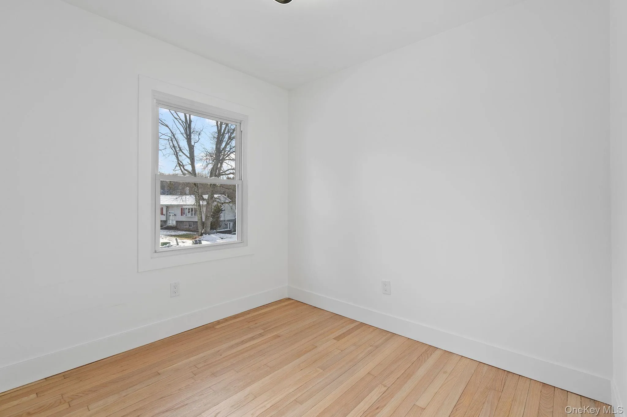 Spare room featuring baseboards and hardwood / wood-style floors Spare room featuring baseboards and hardwood / wood-style floors
