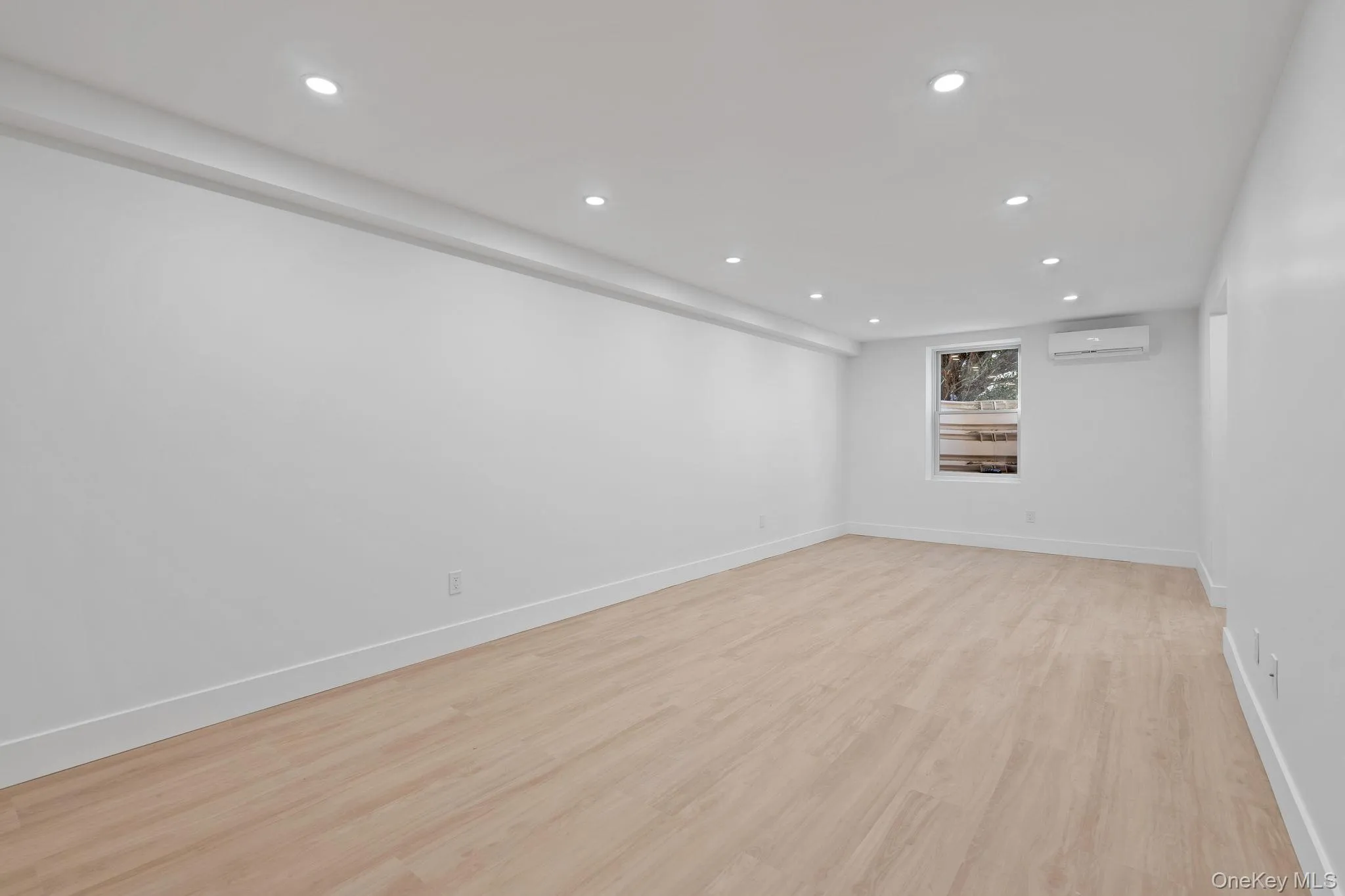 Spare room featuring recessed lighting, light wood-style flooring, and a wall mounted AC Spare room featuring recessed lighting, light wood-style flooring, and a wall mounted AC