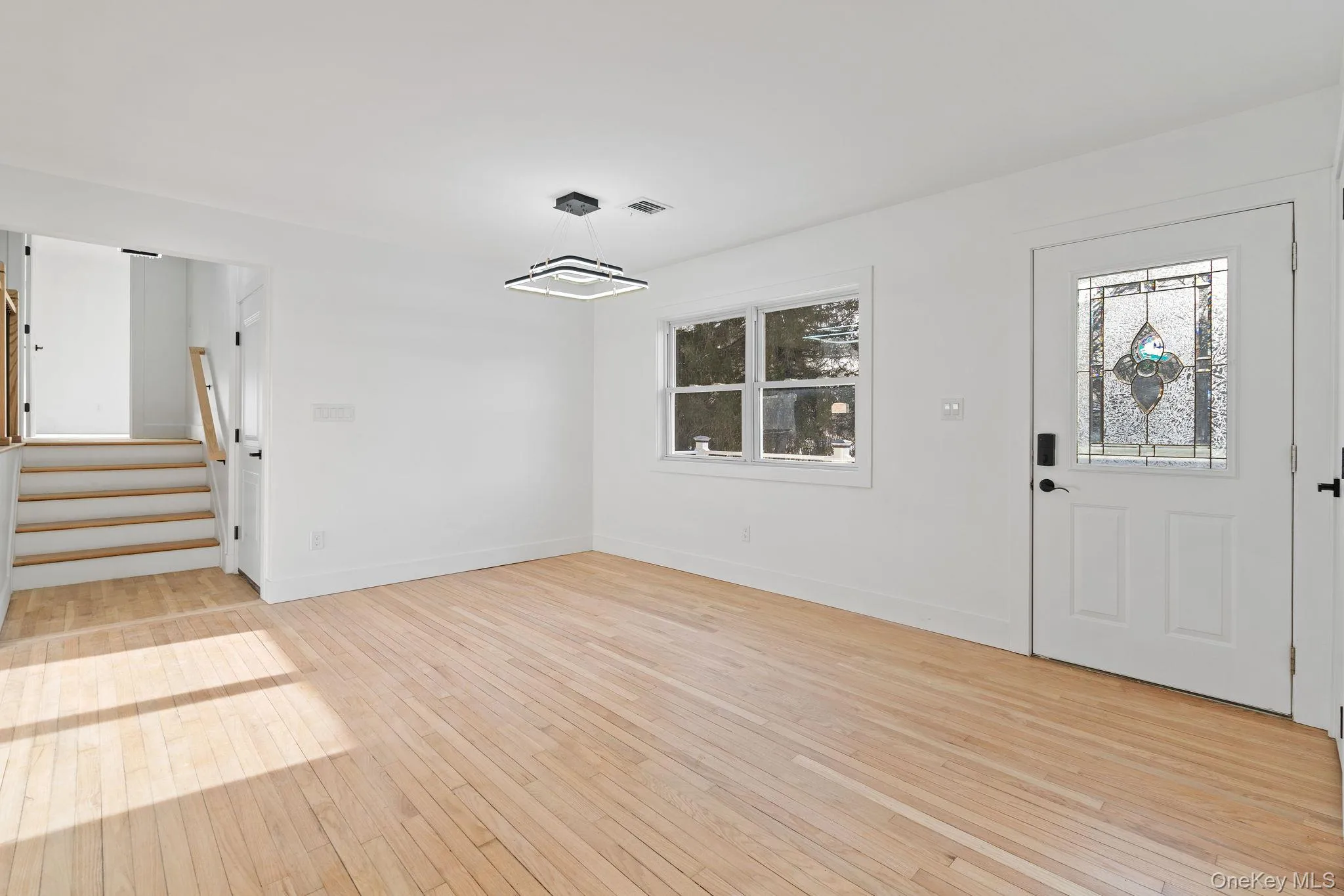 Entryway with stairs and light wood-style flooring Entryway with stairs and light wood-style flooring