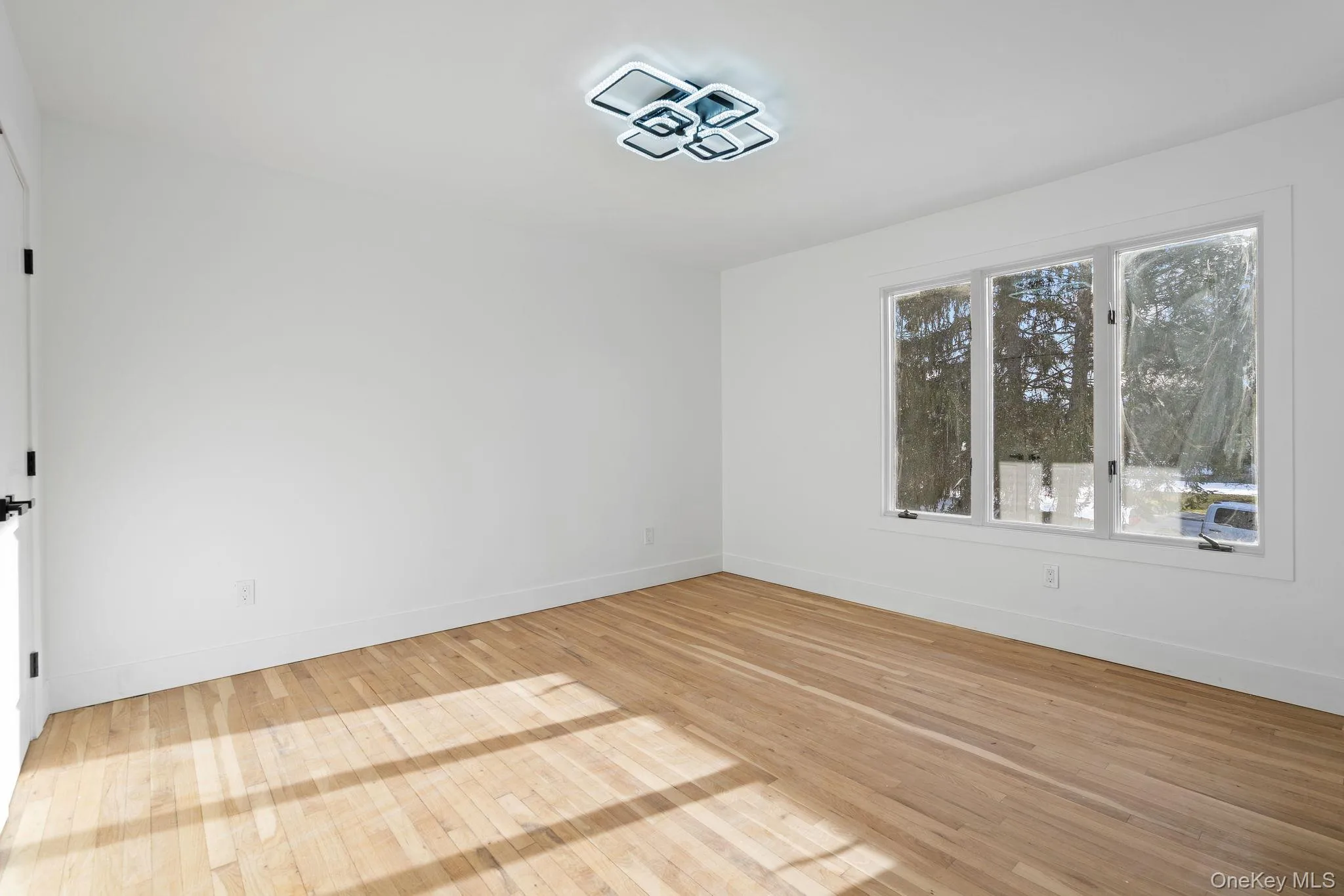 Unfurnished room with light wood-style floors and baseboards Unfurnished room with light wood-style floors and baseboards