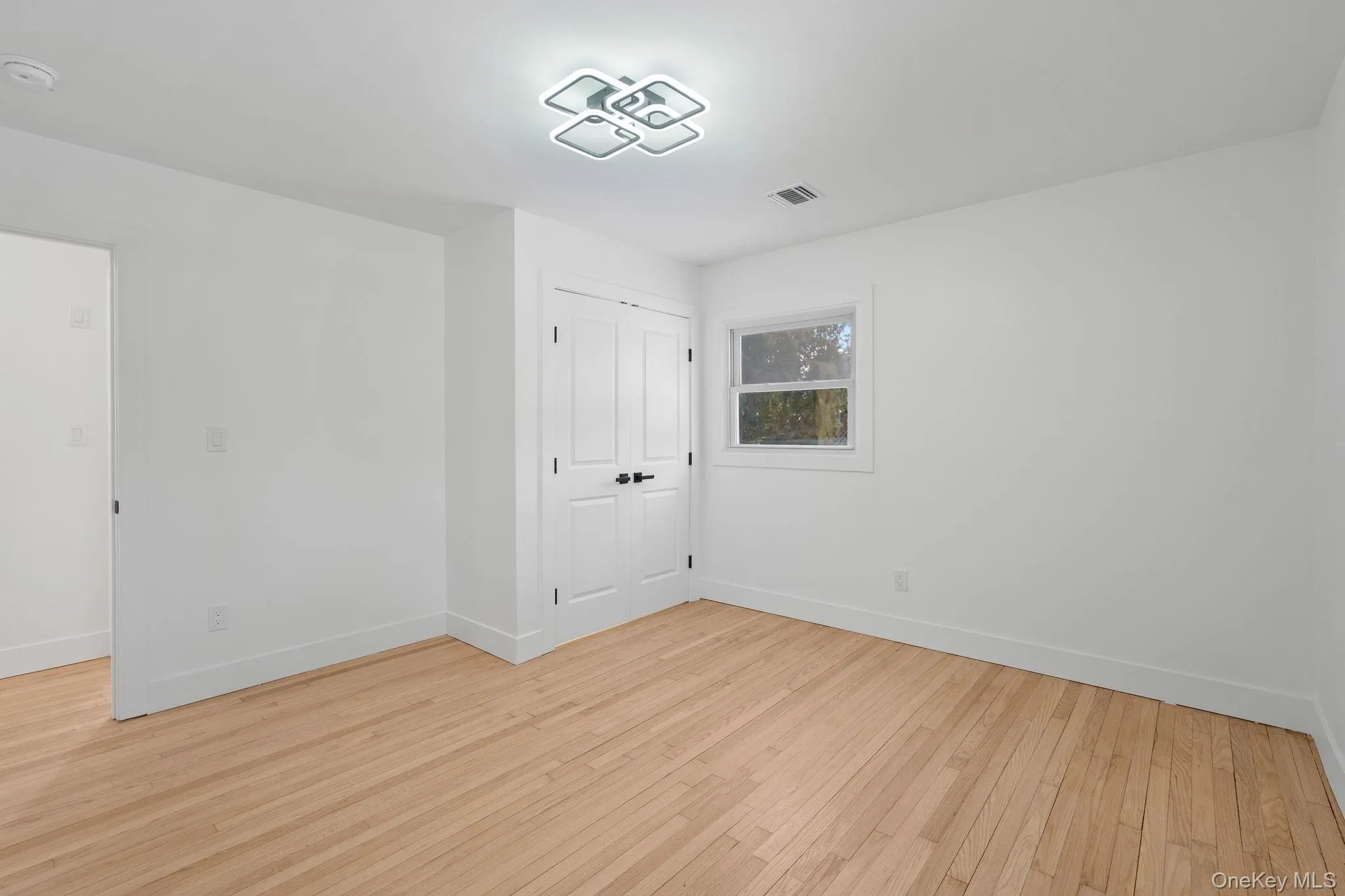 Unfurnished bedroom with light wood-style flooring and a closet Unfurnished bedroom with light wood-style flooring and a closet