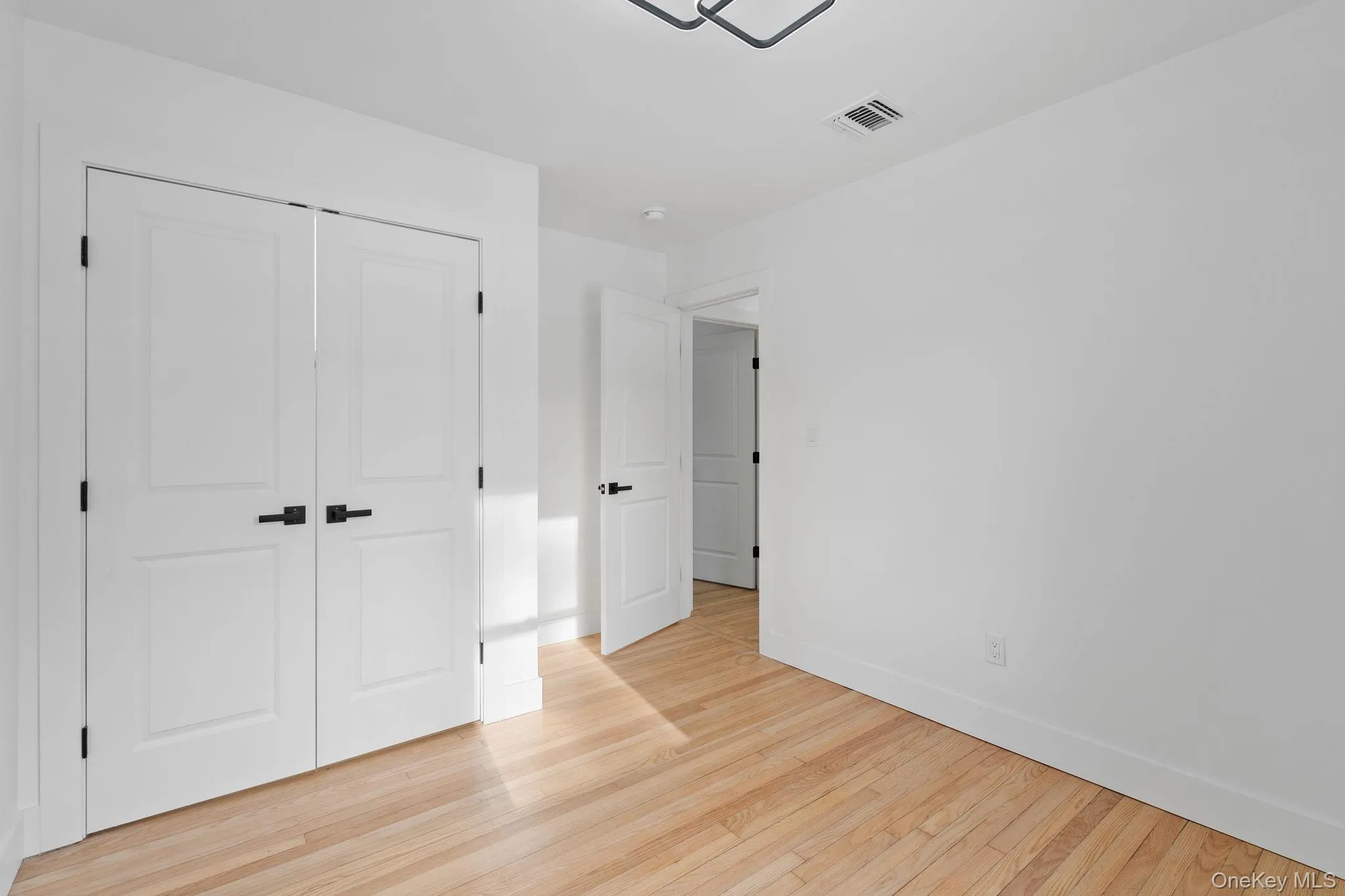 Unfurnished bedroom featuring light wood finished floors and a closet Unfurnished bedroom featuring light wood finished floors and a closet