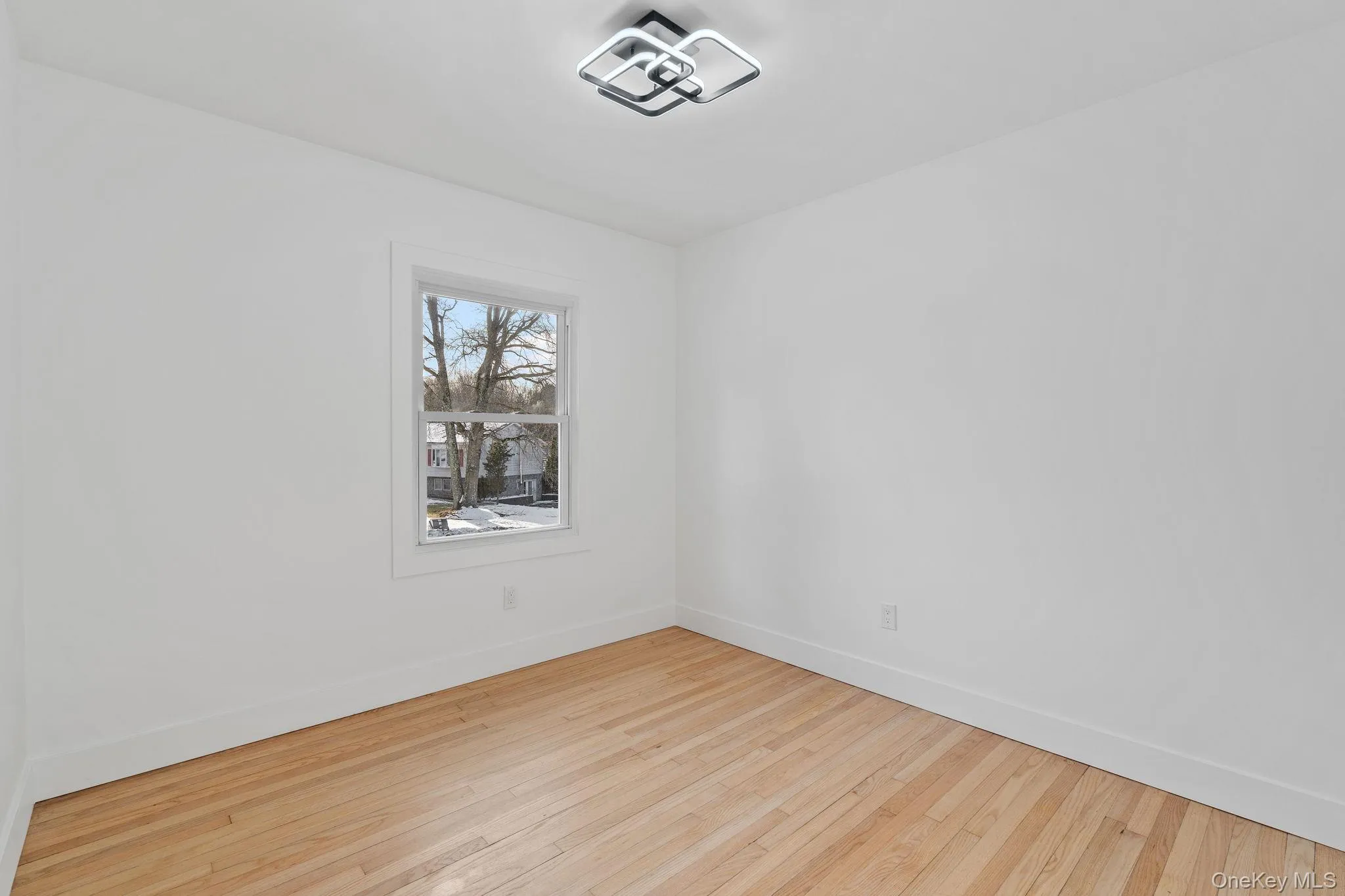 Empty room with baseboards and hardwood / wood-style flooring Empty room with baseboards and hardwood / wood-style flooring
