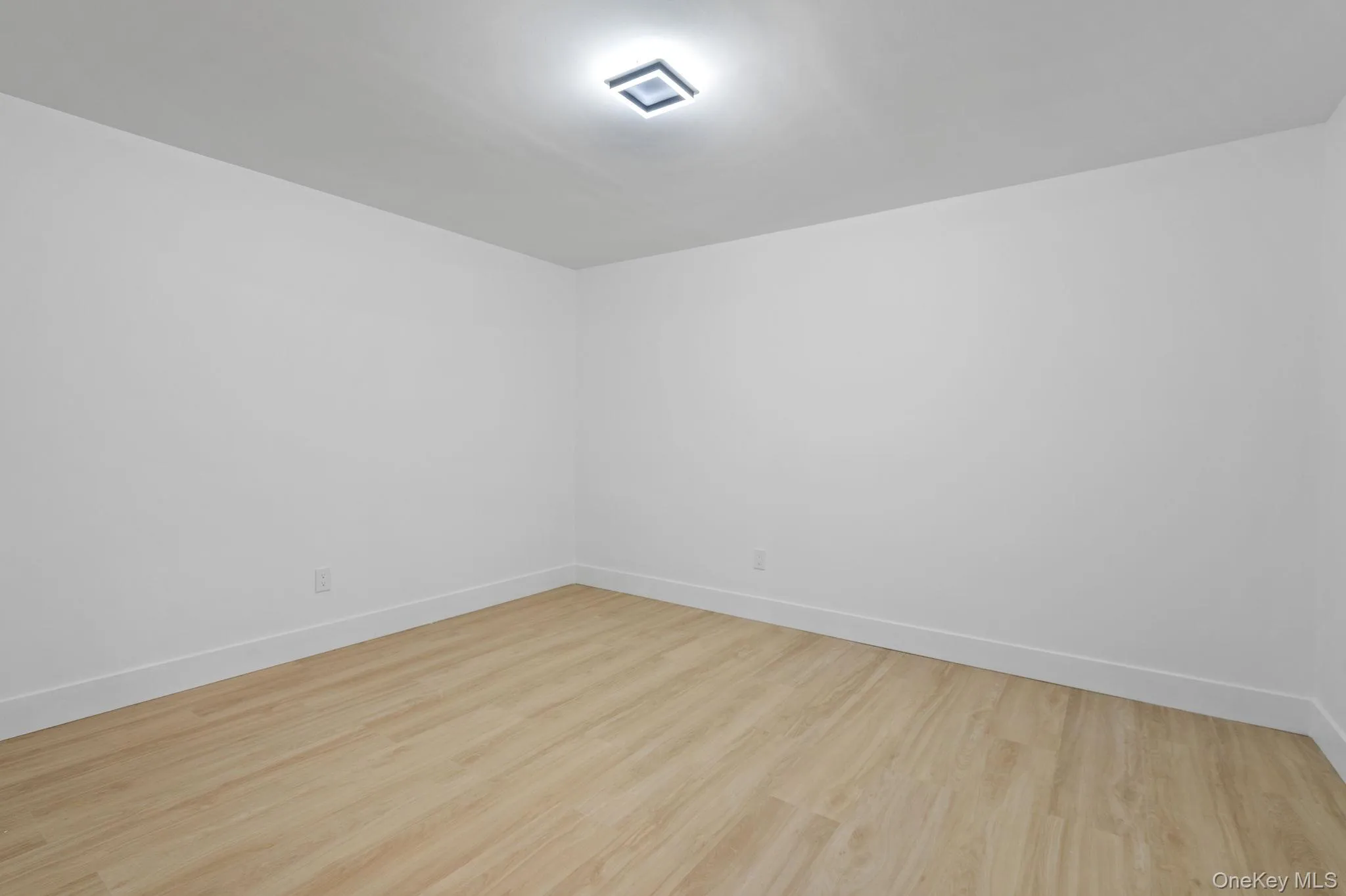 Unfurnished room featuring light wood-style floors and baseboards Unfurnished room featuring light wood-style floors and baseboards