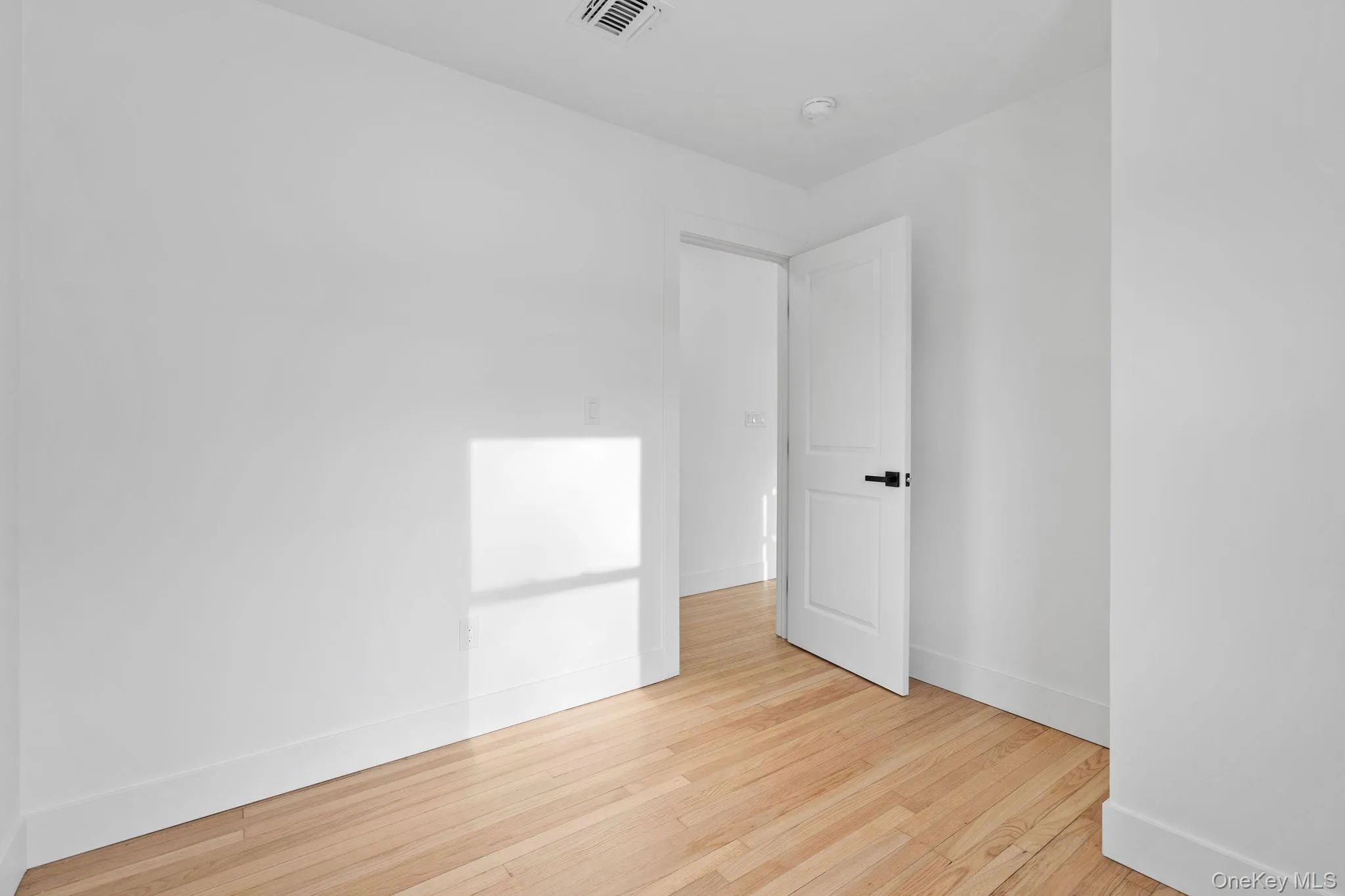 Unfurnished room featuring light wood-style flooring and baseboards Unfurnished room featuring light wood-style flooring and baseboards