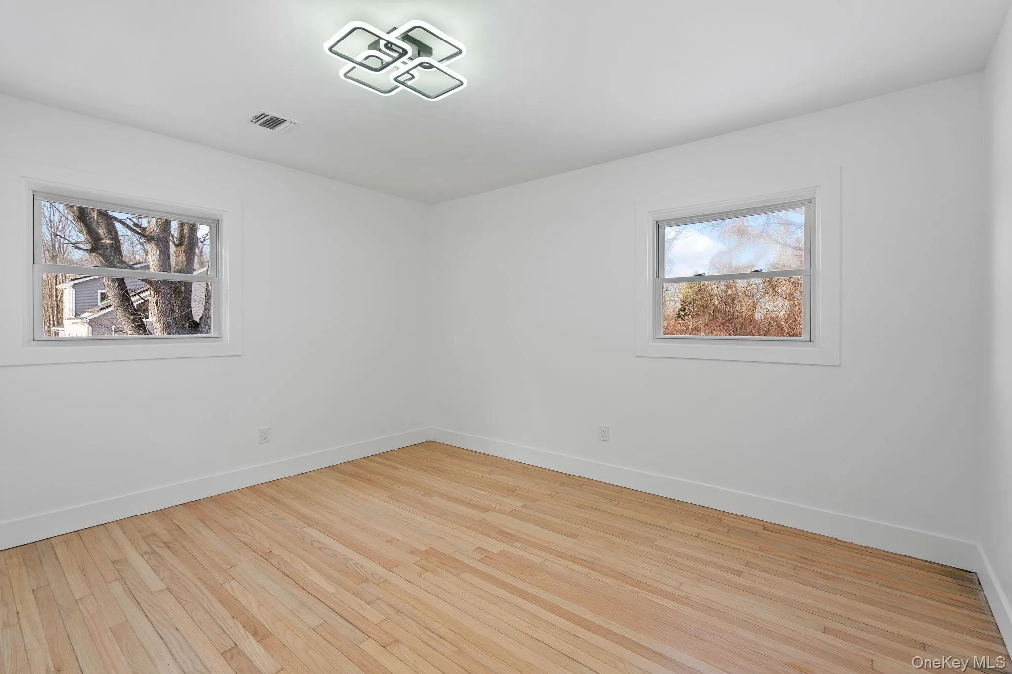 Empty room featuring light wood-style floors and baseboards Empty room featuring light wood-style floors and baseboards