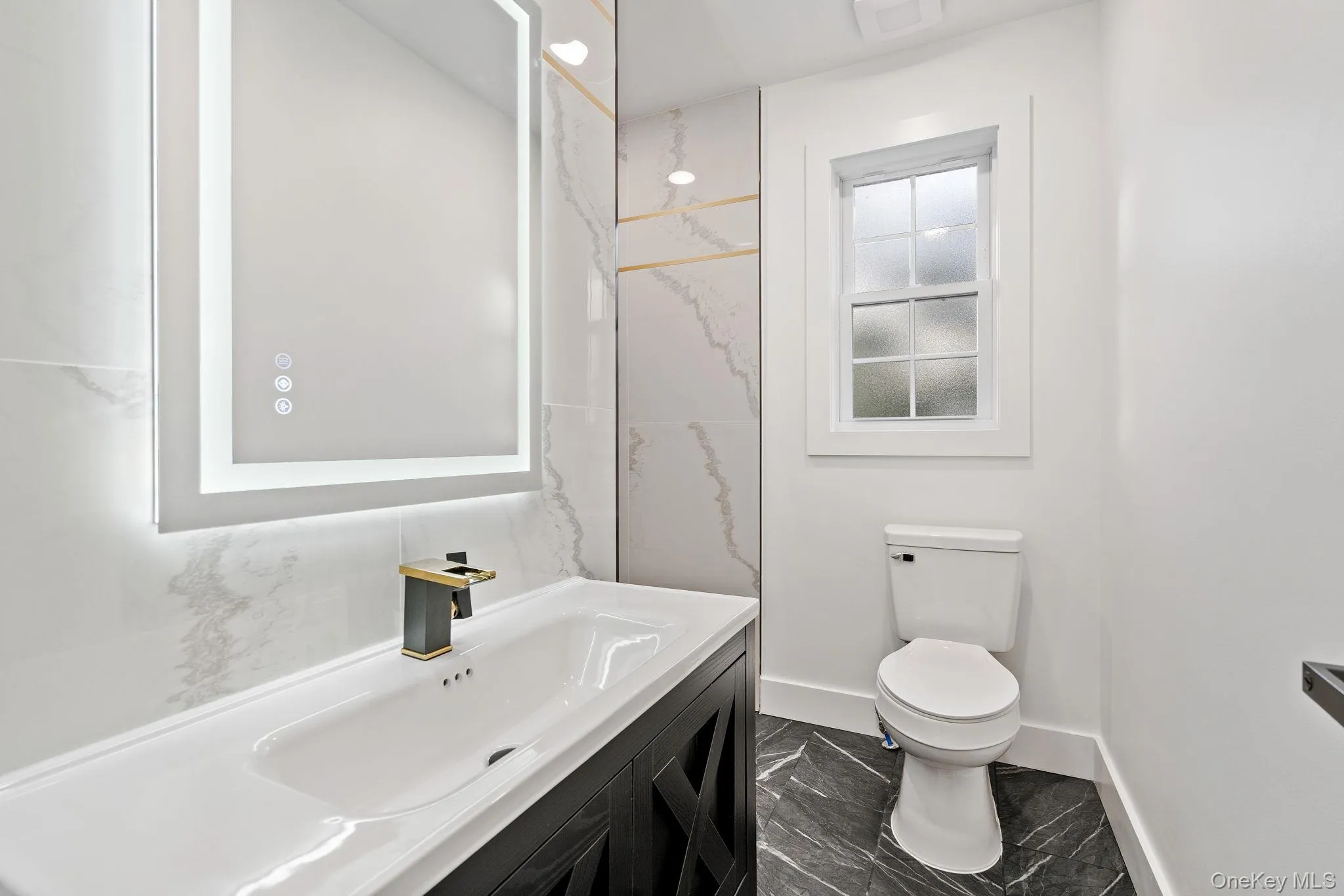 Bathroom with vanity and dark marble finish flooring Bathroom with vanity and dark marble finish flooring