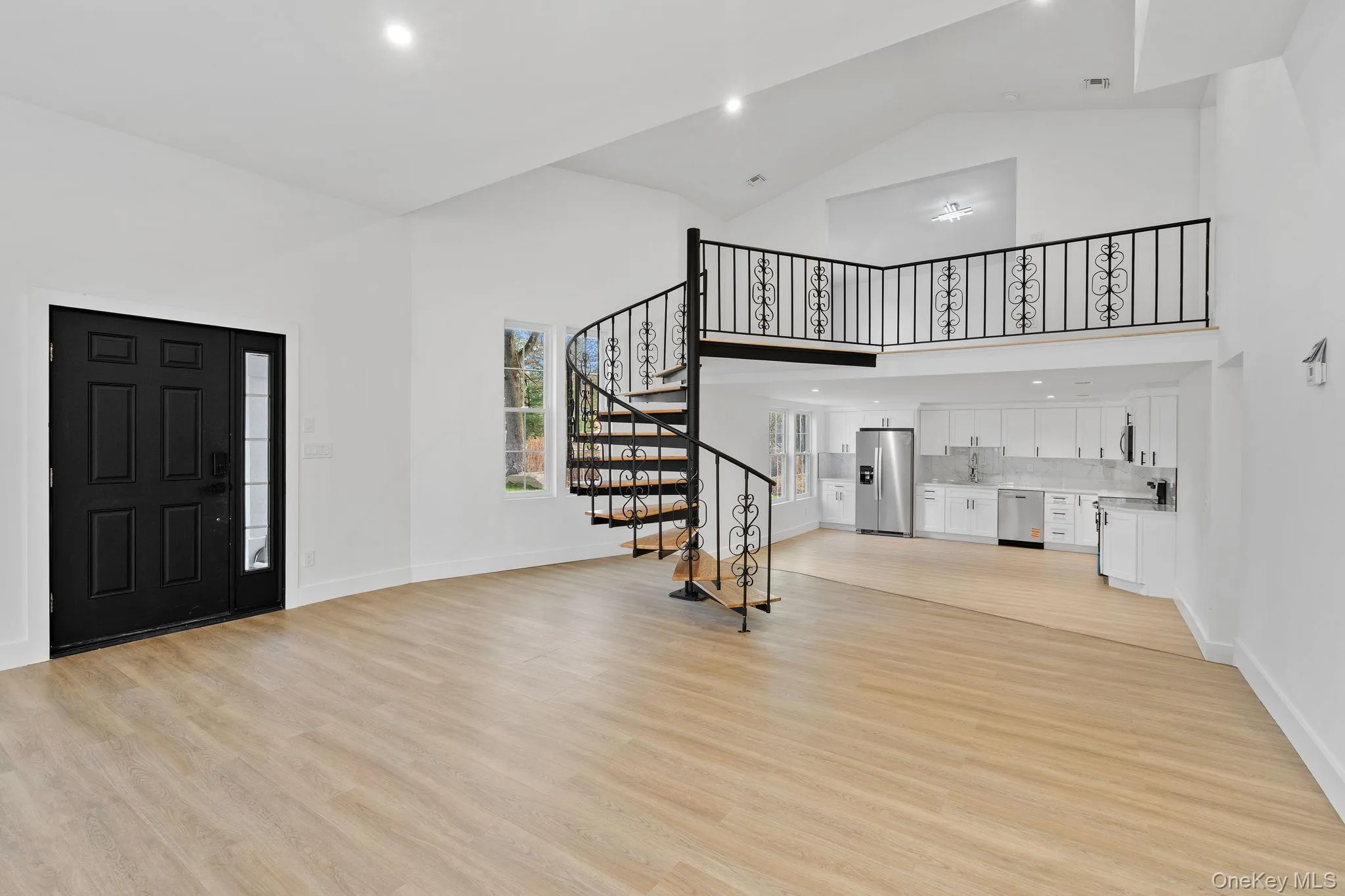 Entrance foyer with light wood-style flooring, stairway, high vaulted ceiling, and recessed lighting Entrance foyer with light wood-style flooring, stairway, high vaulted ceiling, and recessed lighting