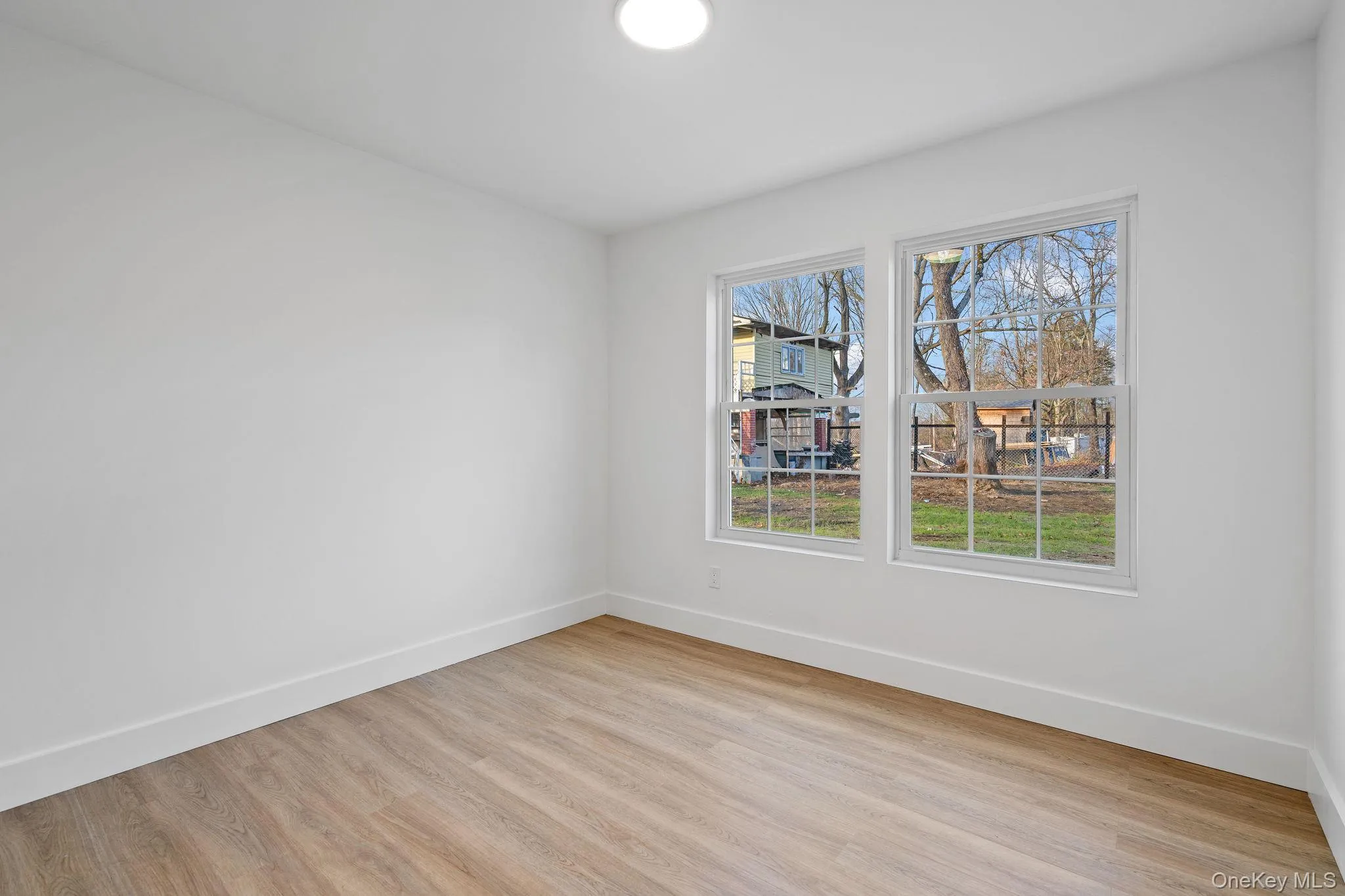 Unfurnished room with baseboards and light wood finished floors Unfurnished room with baseboards and light wood finished floors