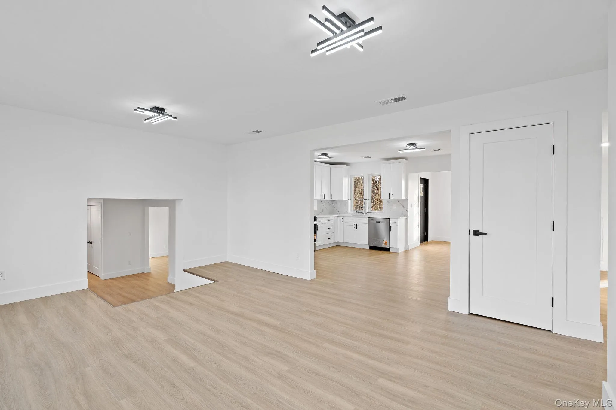 Unfurnished living room featuring light wood-style floors and baseboards Unfurnished living room featuring light wood-style floors and baseboards