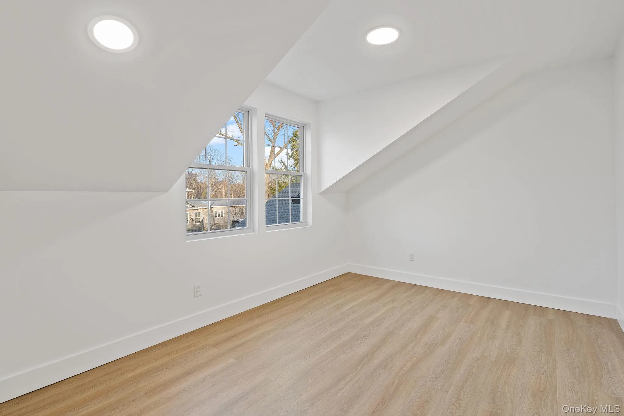 Additional living space with baseboards and light wood-style flooring Additional living space with baseboards and light wood-style flooring