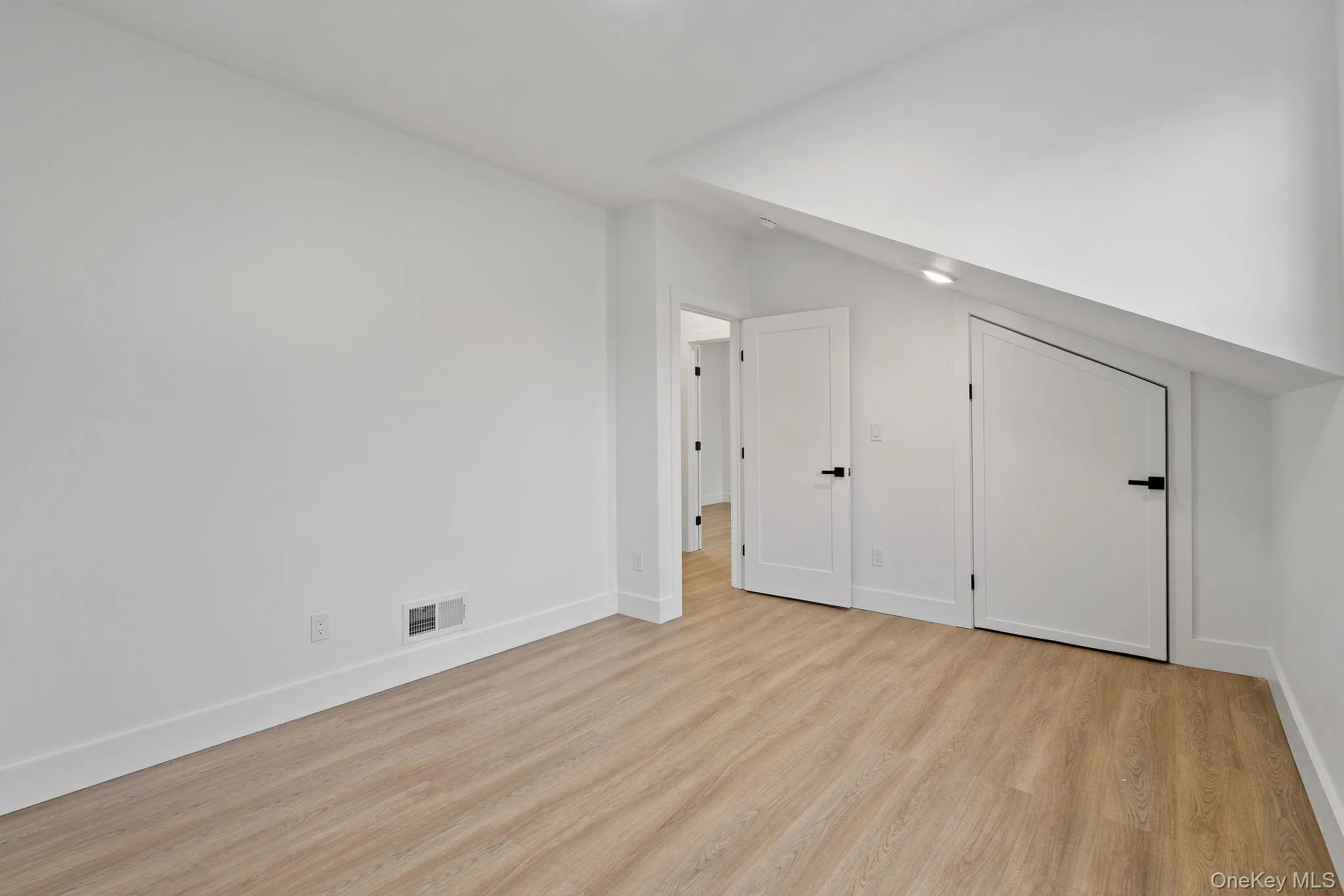 Unfurnished bedroom with light wood-type flooring and baseboards Unfurnished bedroom with light wood-type flooring and baseboards