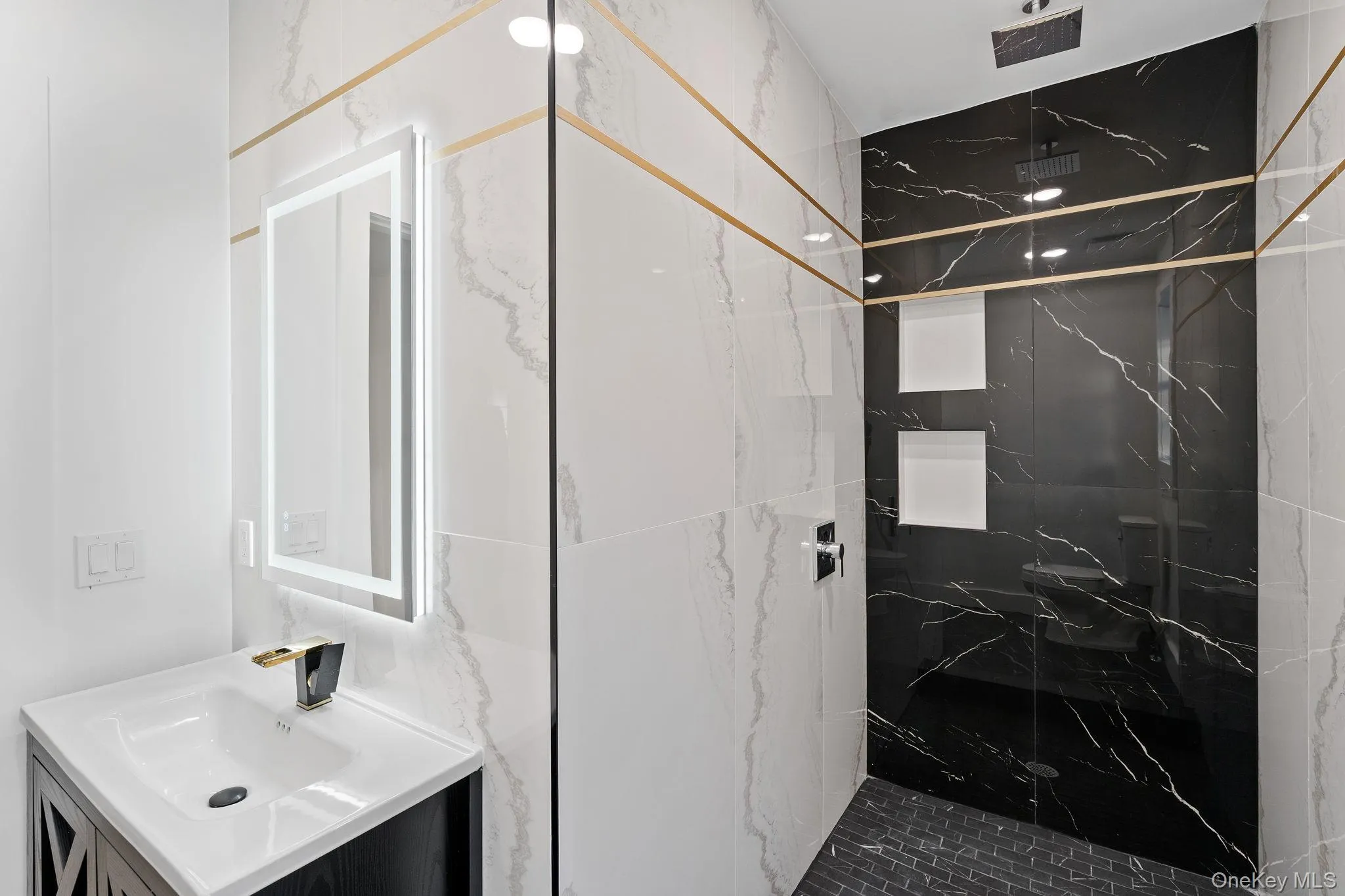 Bathroom featuring vanity and a marble finish shower Bathroom featuring vanity and a marble finish shower