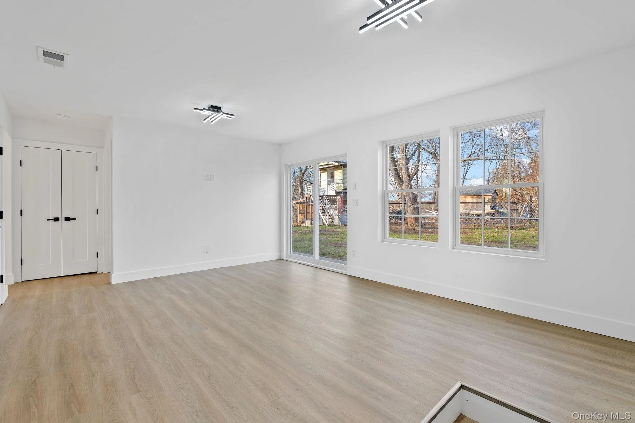 Unfurnished living room with light wood finished floors and baseboards Unfurnished living room with light wood finished floors and baseboards