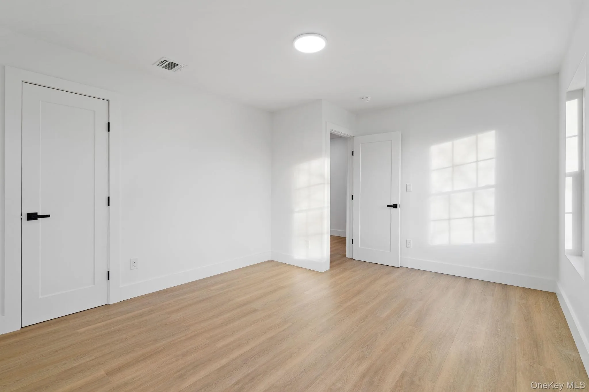 Unfurnished room with light wood-style flooring and baseboards Unfurnished room with light wood-style flooring and baseboards