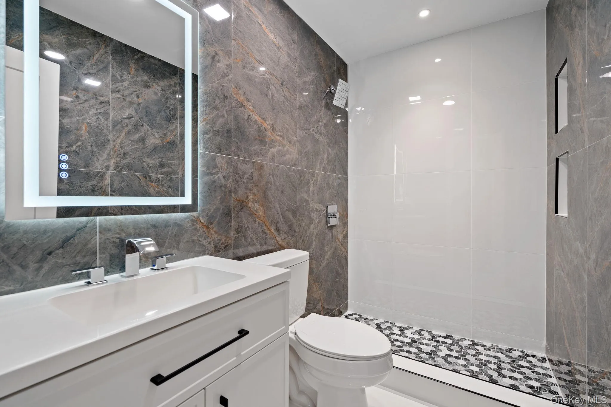 Full bath with tile walls, vanity, a stall shower, and recessed lighting Full bath with tile walls, vanity, a stall shower, and recessed lighting