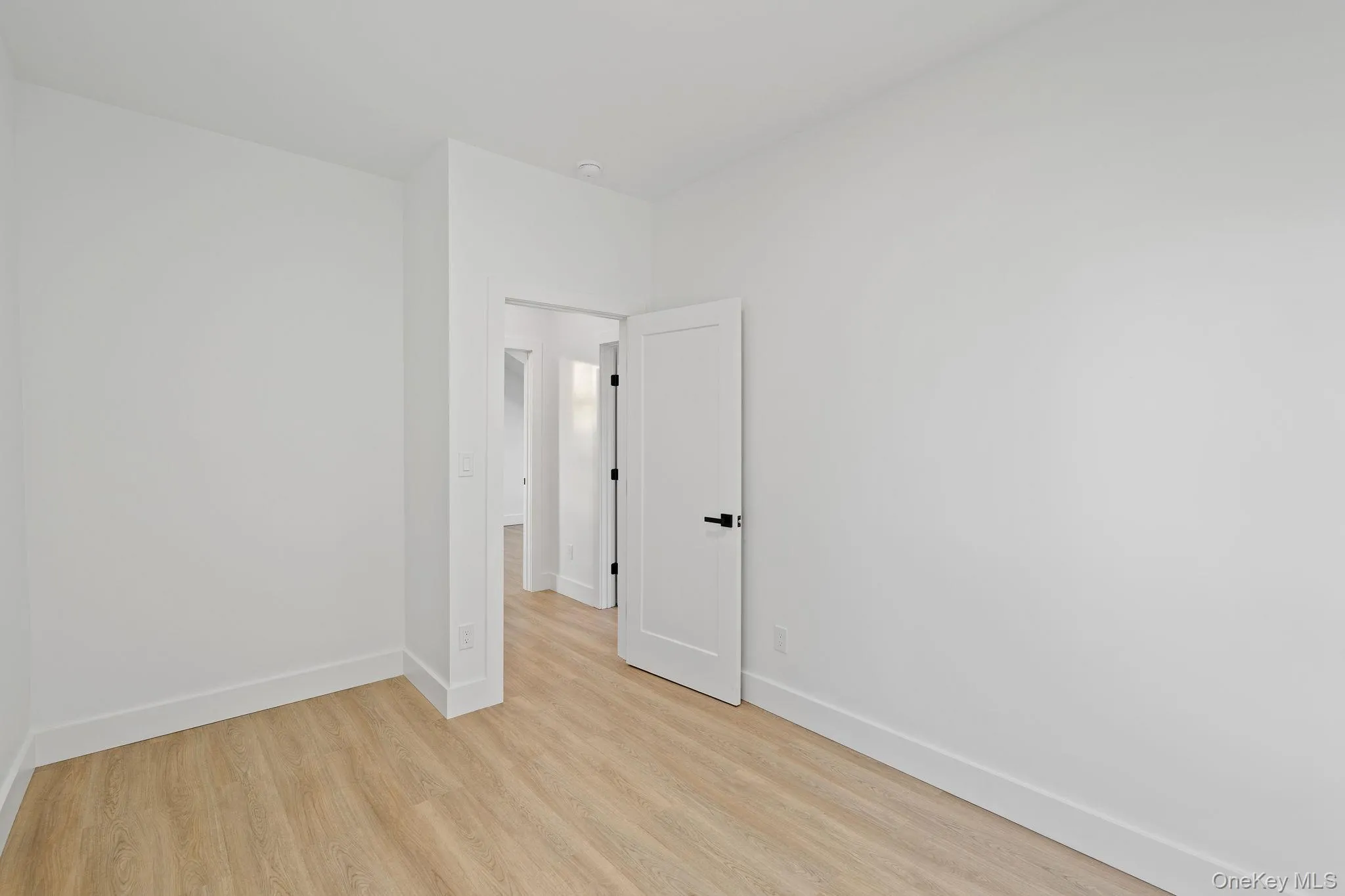 Empty room featuring baseboards and light wood finished floors Empty room featuring baseboards and light wood finished floors