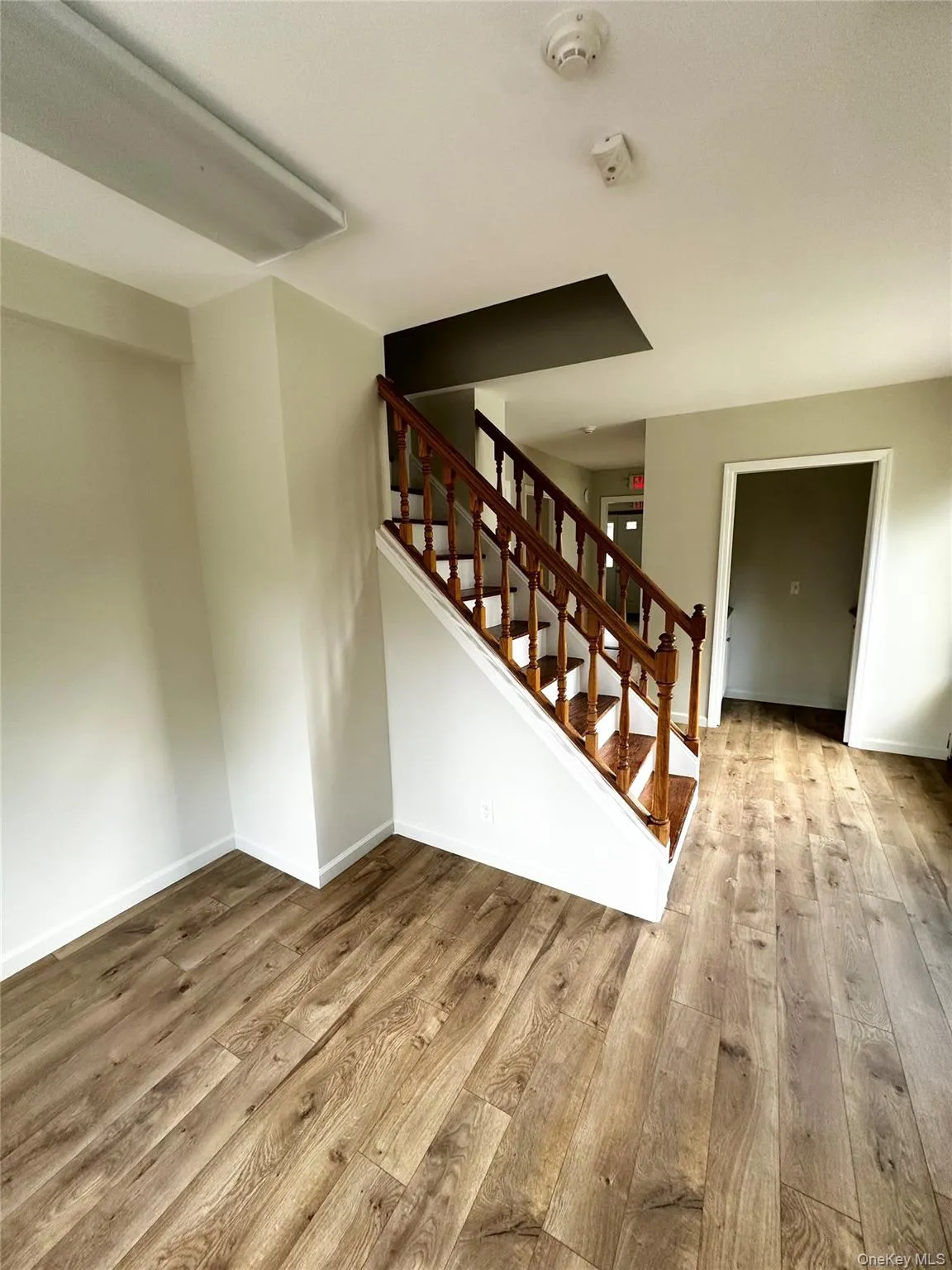 Unfurnished living room featuring stairway and wood finished floors Unfurnished living room featuring stairway and wood finished floors