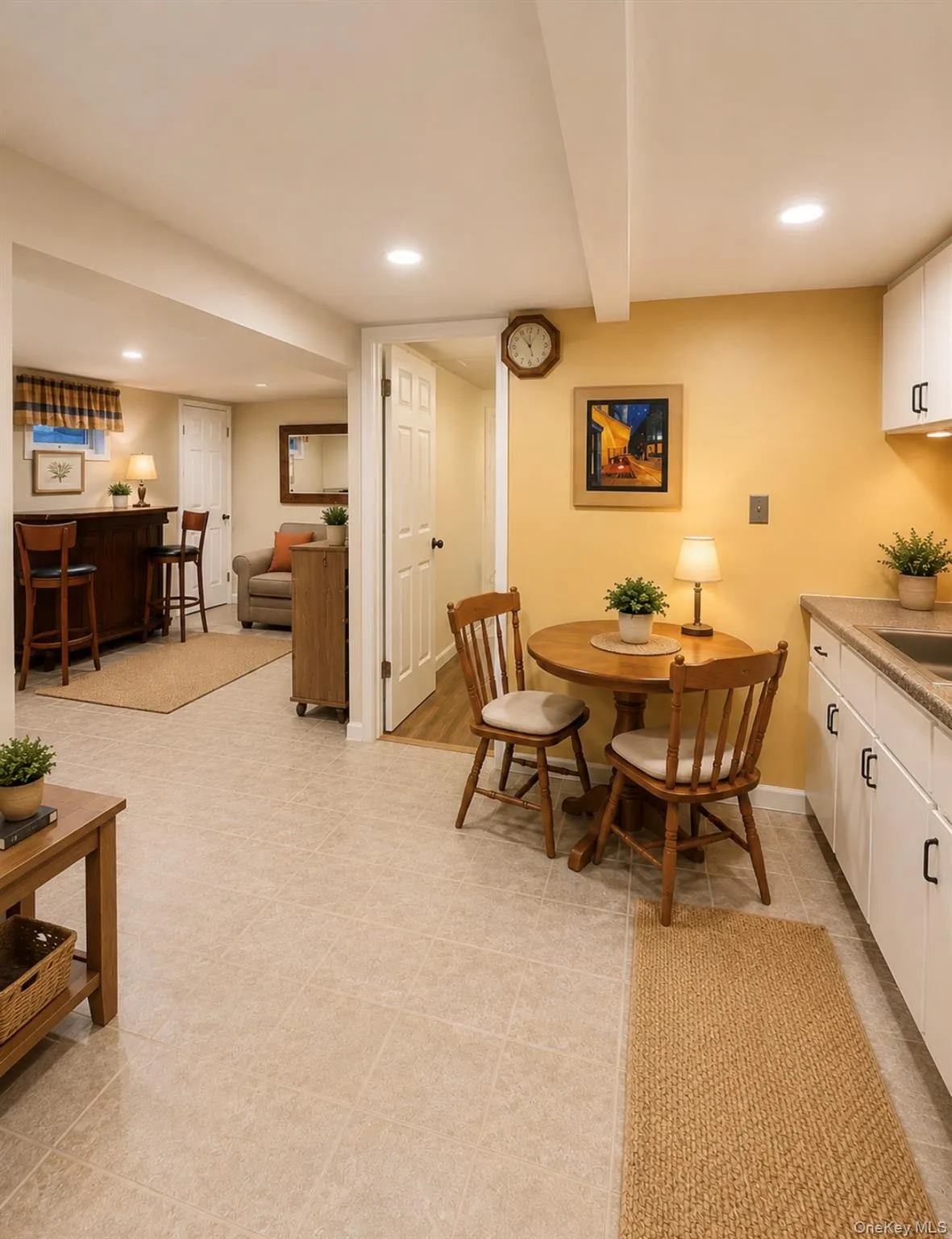 Finished lower level featuring recessed lighting, tile flooring, a kitchenette with white cabinetry, and a wet bar area with a built-in counter Finished lower level featuring recessed lighting, tile flooring, a kitchenette with white cabinetry, and a wet bar area with a built-in counter