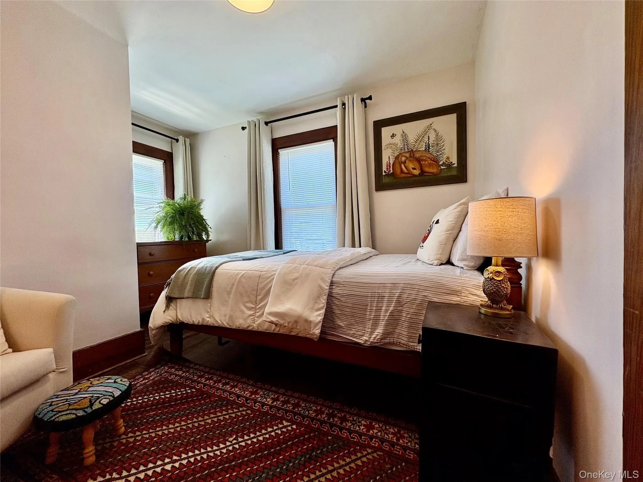 Bedroom featuring light-toned walls and wood-finish trim Bedroom featuring light-toned walls and wood-finish trim