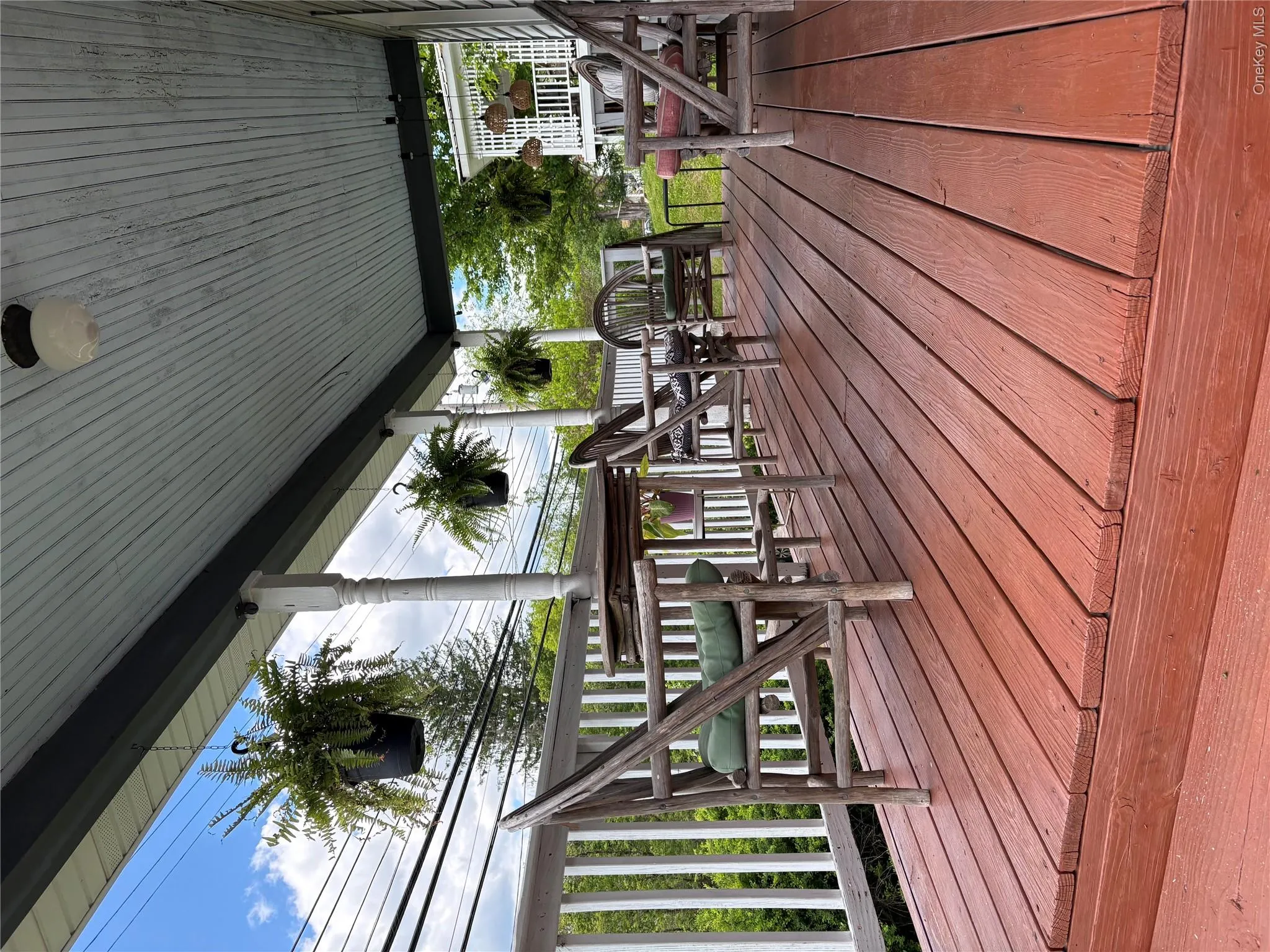 Spacious covered porch with a painted wood floor and white baluster railing Spacious covered porch with a painted wood floor and white baluster railing