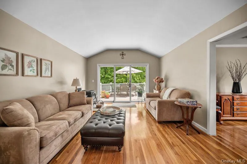 Living room with hardwood floors through and sliders to oversized deck Living room with hardwood floors through and sliders to oversized deck