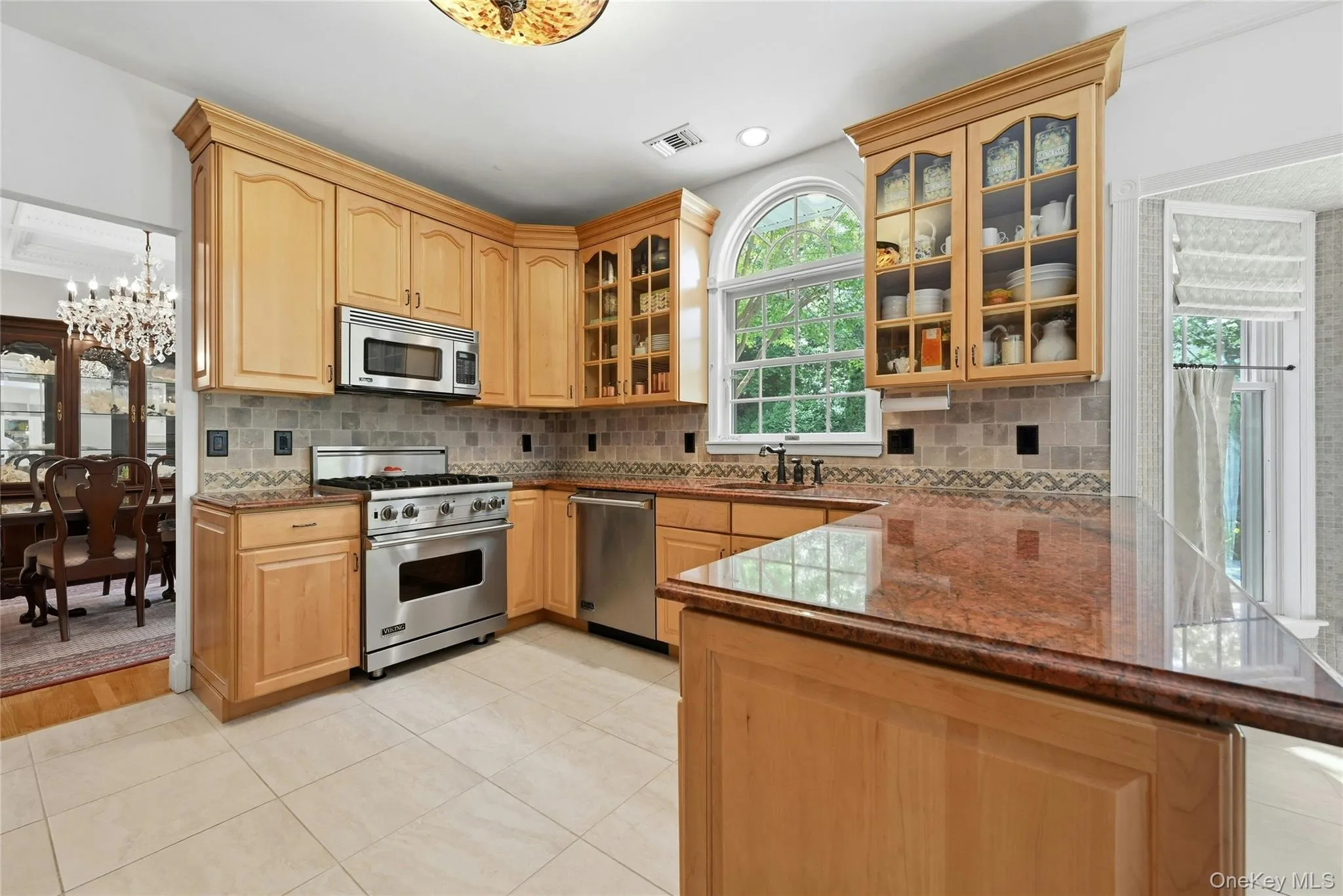 The Spectacular Three Year Old Chef's Kitchen Offers Walls Of Extra Height Custom Maple Cabinetry With Beautiful Moldings, Detailwork & Trims, Glass Doors, Premium Granite Countertops With Expansive Counter/Serving Areas, Tiled Backsplash With Accent Border, Stunning Circle Topped Window Over The Sink, A Suite Of Viking Stainless Steel Appliances (Including A Gas Range), Porcelain Tiled Floors & A Large Dinette Area Which Opens Into The Family Room/Den. The Spectacular Three Year Old Chef's Kitchen Offers Walls Of Extra Height Custom Maple Cabinetry With Beautiful Moldings, Detailwork & Trims, Glass Doors, Premium Granite Countertops With Expansive Counter/Serving Areas, Tiled Backsplash With Accent Border, Stunning Circle Topped Window Over The Sink, A Suite Of Viking Stainless Steel Appliances (Including A Gas Range), Porcelain Tiled Floors & A Large Dinette Area Which Opens Into The Family Room/Den.