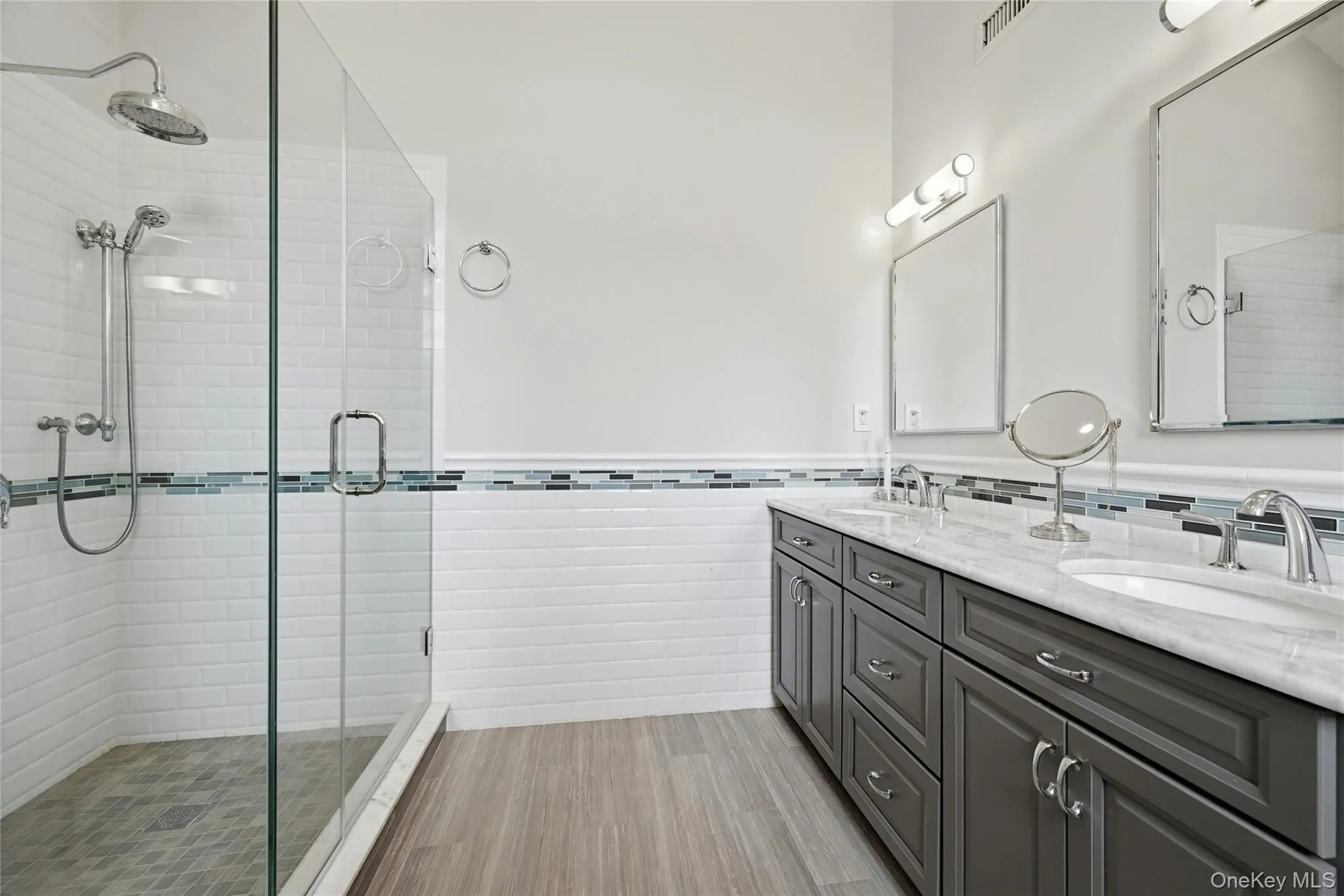 Another View Of The Primary Bathroom Which Is A Page Out Of Architectural Digest Magazine - A Stunning Free Standing Antique Style Tub With High End Fixtures, Soaring Ceilings With An Accent Circle Topped Window & Chandelier, Oversized Custom Shower With Classic Subway Tiled Walls & Wraparound Frameless Glass Doors (Original Walls Removed When The Bathroom Was Redesigned), All Subway Tiled Walls With Decorative Borders, Custom Dual Sink Marble Topped Vanity, Porcelain Plank Tiled Floors & All Upgraded Fixtures...A True Showplace. Another View Of The Primary Bathroom Which Is A Page Out Of Architectural Digest Magazine - A Stunning Free Standing Antique Style Tub With High End Fixtures, Soaring Ceilings With An Accent Circle Topped Window & Chandelier, Oversized Custom Shower With Classic Subway Tiled Walls & Wraparound Frameless Glass Doors (Original Walls Removed When The Bathroom Was Redesigned), All Subway Tiled Walls With Decorative Borders, Custom Dual Sink Marble Topped Vanity, Porcelain Plank Tiled Floors & All Upgraded Fixtures...A True Showplace.