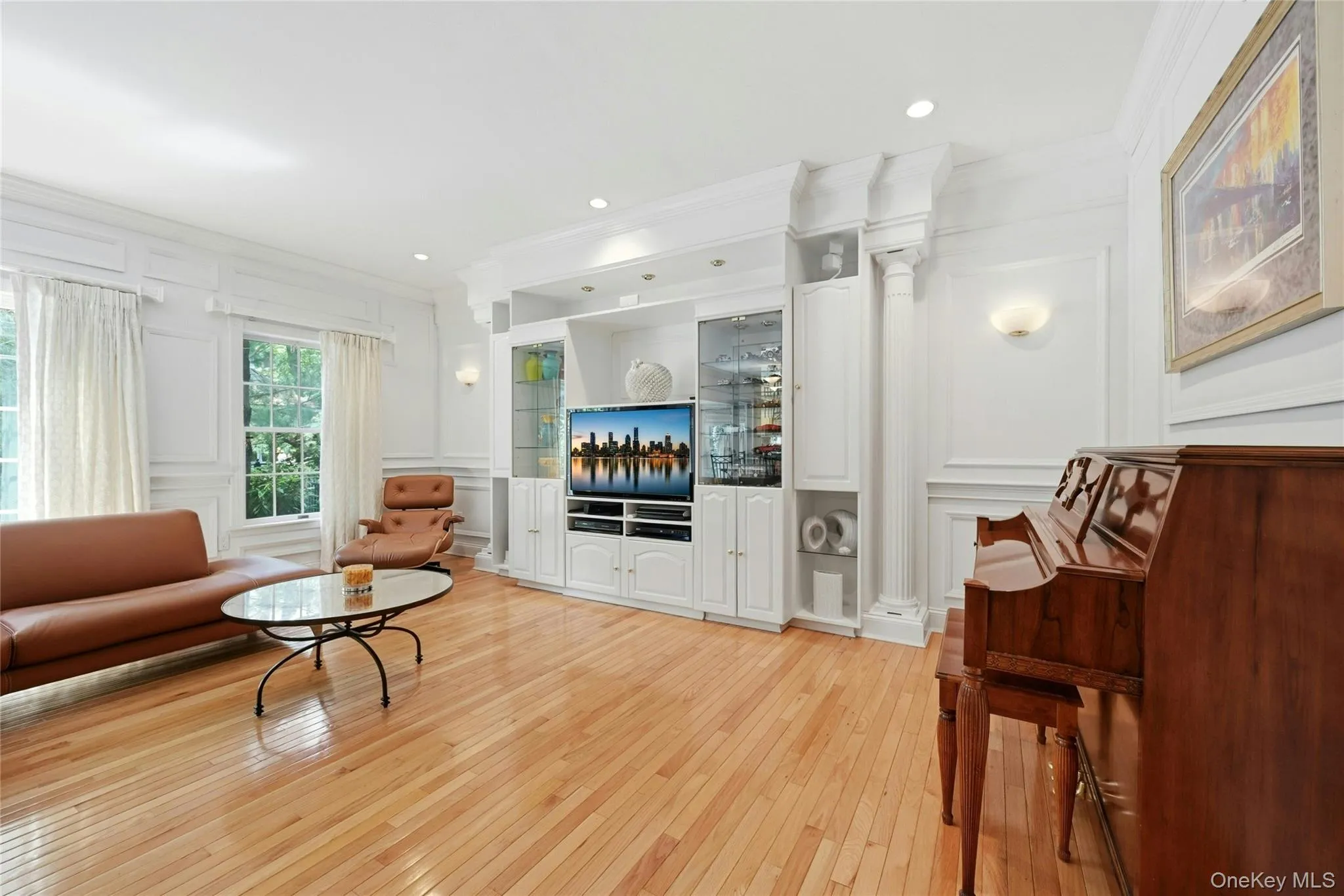 Another View Of The Expansive 20'3" x 18'8" Den/Family Room Which Was Expanded Two Feet Out The Back Of The Home & An Additional Two Feet Towards The Garage Offering A Perfect, Vast Space For Entertaining With 9' Ceilings, Stunning Box Paneled/Wainscoted Walls, Beautiful Hardwood Floors, Andersen Sliding Doors & Oversized Windows Overlooking The Backyard & In Ground Pool, A Striking Custom Built Wall Unit/Entertainment Center With Magnificent Crown Moldings, Columns, Glass Doors & Shelving, Built In Television (Which Stays With The Home) & Built In Lighting, Ample Room For A Very Large Furniture/Seating Area, And Access To The Half Bathroom/Powder Room & Two Car Garage. Another View Of The Expansive 20'3" x 18'8" Den/Family Room Which Was Expanded Two Feet Out The Back Of The Home & An Additional Two Feet Towards The Garage Offering A Perfect, Vast Space For Entertaining With 9' Ceilings, Stunning Box Paneled/Wainscoted Walls, Beautiful Hardwood Floors, Andersen Sliding Doors & Oversized Windows Overlooking The Backyard & In Ground Pool, A Striking Custom Built Wall Unit/Entertainment Center With Magnificent Crown Moldings, Columns, Glass Doors & Shelving, Built In Television (Which Stays With The Home) & Built In Lighting, Ample Room For A Very Large Furniture/Seating Area, And Access To The Half Bathroom/Powder Room & Two Car Garage.