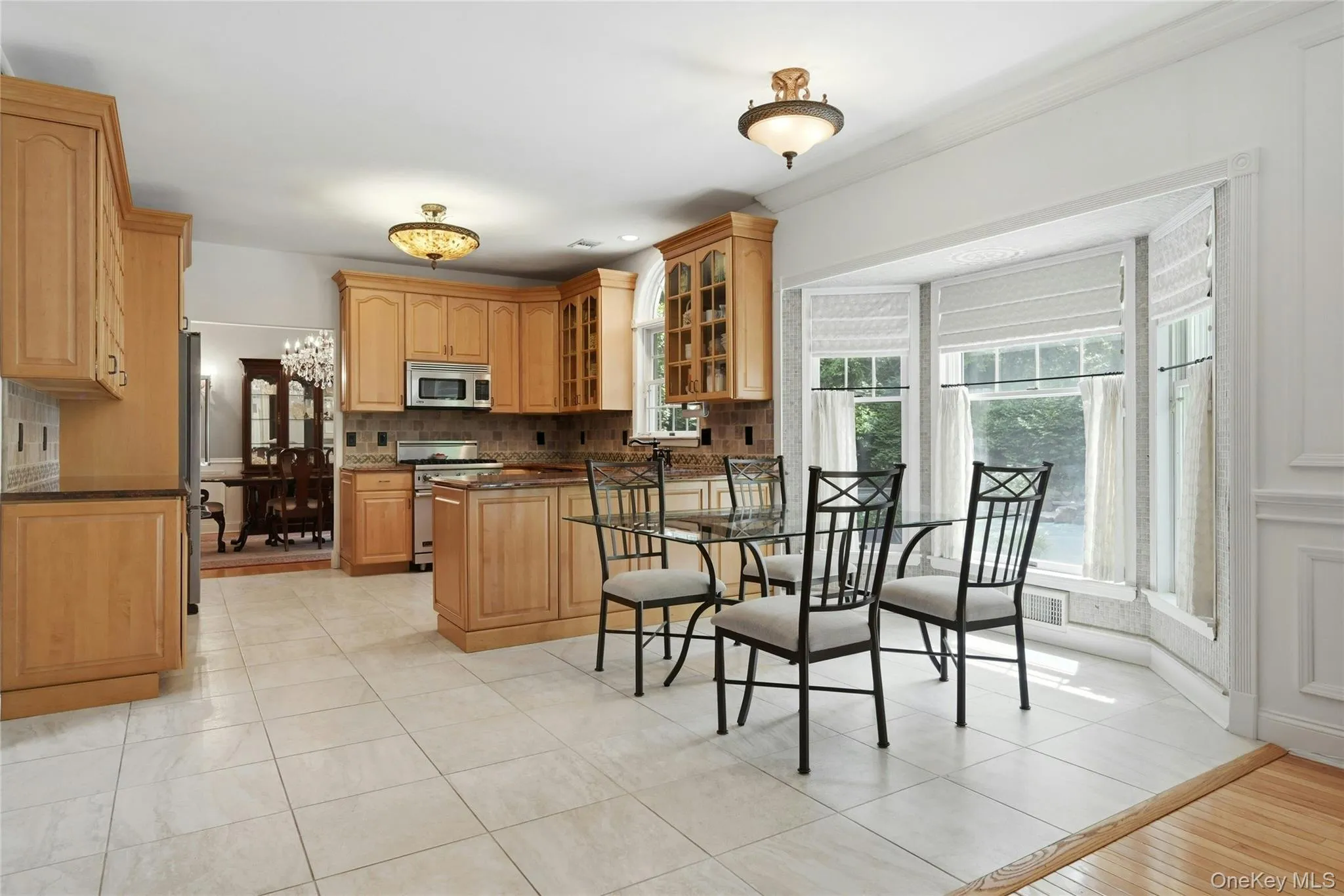 The Spectacular Three Year Old Chef's Kitchen Offers Walls Of Extra Height Custom Maple Cabinetry With Beautiful Moldings, Detailwork & Trims, Glass Doors, Premium Granite Countertops With Expansive Counter/Serving Areas, Tiled Backsplash With Accent Border, Stunning Circle Topped Window Over The Sink, A Suite Of Viking Stainless Steel Appliances (Including A Gas Range), Porcelain Tiled Floors & A Large Dinette Area Which Opens Into The Family Room/Den. The Spectacular Three Year Old Chef's Kitchen Offers Walls Of Extra Height Custom Maple Cabinetry With Beautiful Moldings, Detailwork & Trims, Glass Doors, Premium Granite Countertops With Expansive Counter/Serving Areas, Tiled Backsplash With Accent Border, Stunning Circle Topped Window Over The Sink, A Suite Of Viking Stainless Steel Appliances (Including A Gas Range), Porcelain Tiled Floors & A Large Dinette Area Which Opens Into The Family Room/Den.