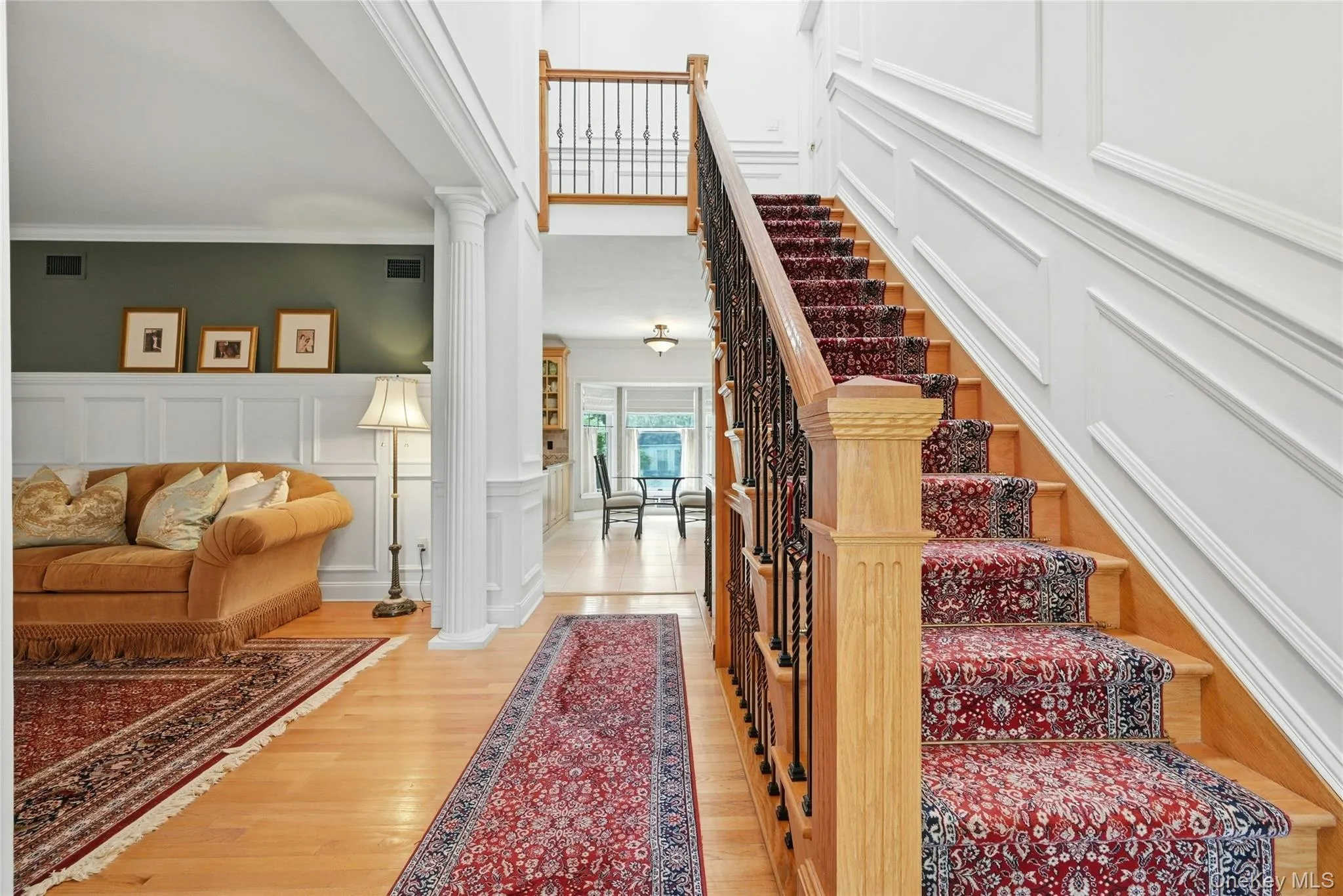 Another View Of The Exquisite Formal Entrance Foyer Offering A Stunning Two Story Stairway To To The Second Level With Custom Oak & Wrought Iron Bannisters, Railings, Spindles & Stairs, Magnificent Fully Floor To Ceiling Box Paneled/Wainscoted Walls, Beautiful Hardwood Floors, A Two Column Entrance Into The Formal Living Room & Then Opens Into The Kitchen, Dinette And Den/Family Room. Another View Of The Exquisite Formal Entrance Foyer Offering A Stunning Two Story Stairway To To The Second Level With Custom Oak & Wrought Iron Bannisters, Railings, Spindles & Stairs, Magnificent Fully Floor To Ceiling Box Paneled/Wainscoted Walls, Beautiful Hardwood Floors, A Two Column Entrance Into The Formal Living Room & Then Opens Into The Kitchen, Dinette And Den/Family Room.