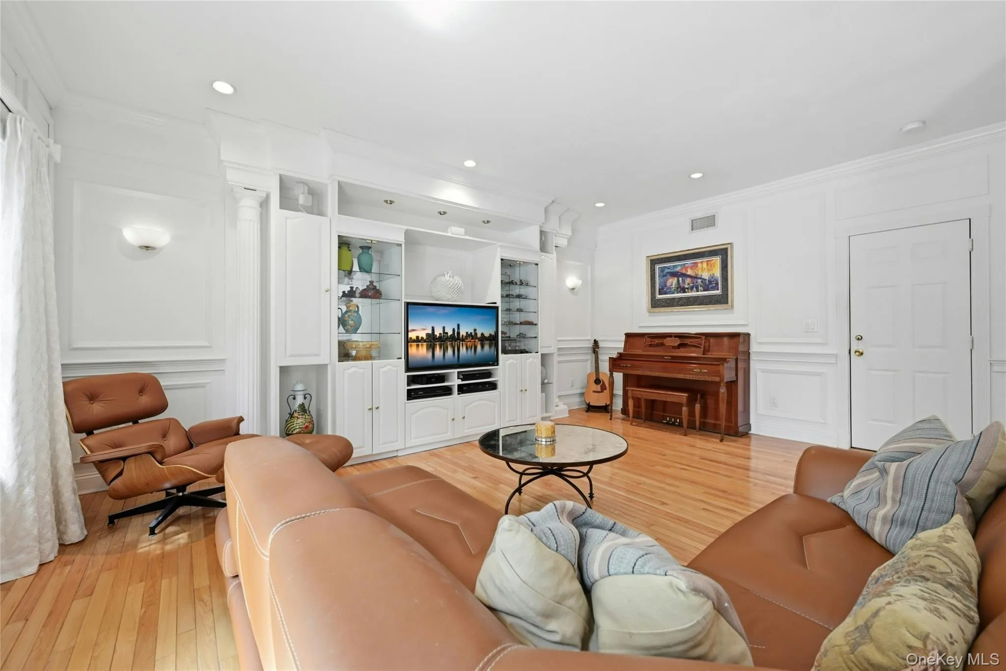 Another View Of The Expansive 20'3" x 18'8" Den/Family Room Which Was Expanded Two Feet Out The Back Of The Home & An Additional Two Feet Towards The Garage Offering A Perfect, Vast Space For Entertaining With 9' Ceilings, Stunning Box Paneled/Wainscoted Walls, Beautiful Hardwood Floors, Andersen Sliding Doors & Oversized Windows Overlooking The Backyard & In Ground Pool, A Striking Custom Built Wall Unit/Entertainment Center With Magnificent Crown Moldings, Columns, Glass Doors & Shelving, Built In Television (Which Stays With The Home) & Built In Lighting, Ample Room For A Very Large Furniture/Seating Area, And Access To The Half Bathroom/Powder Room & Two Car Garage. Another View Of The Expansive 20'3" x 18'8" Den/Family Room Which Was Expanded Two Feet Out The Back Of The Home & An Additional Two Feet Towards The Garage Offering A Perfect, Vast Space For Entertaining With 9' Ceilings, Stunning Box Paneled/Wainscoted Walls, Beautiful Hardwood Floors, Andersen Sliding Doors & Oversized Windows Overlooking The Backyard & In Ground Pool, A Striking Custom Built Wall Unit/Entertainment Center With Magnificent Crown Moldings, Columns, Glass Doors & Shelving, Built In Television (Which Stays With The Home) & Built In Lighting, Ample Room For A Very Large Furniture/Seating Area, And Access To The Half Bathroom/Powder Room & Two Car Garage.