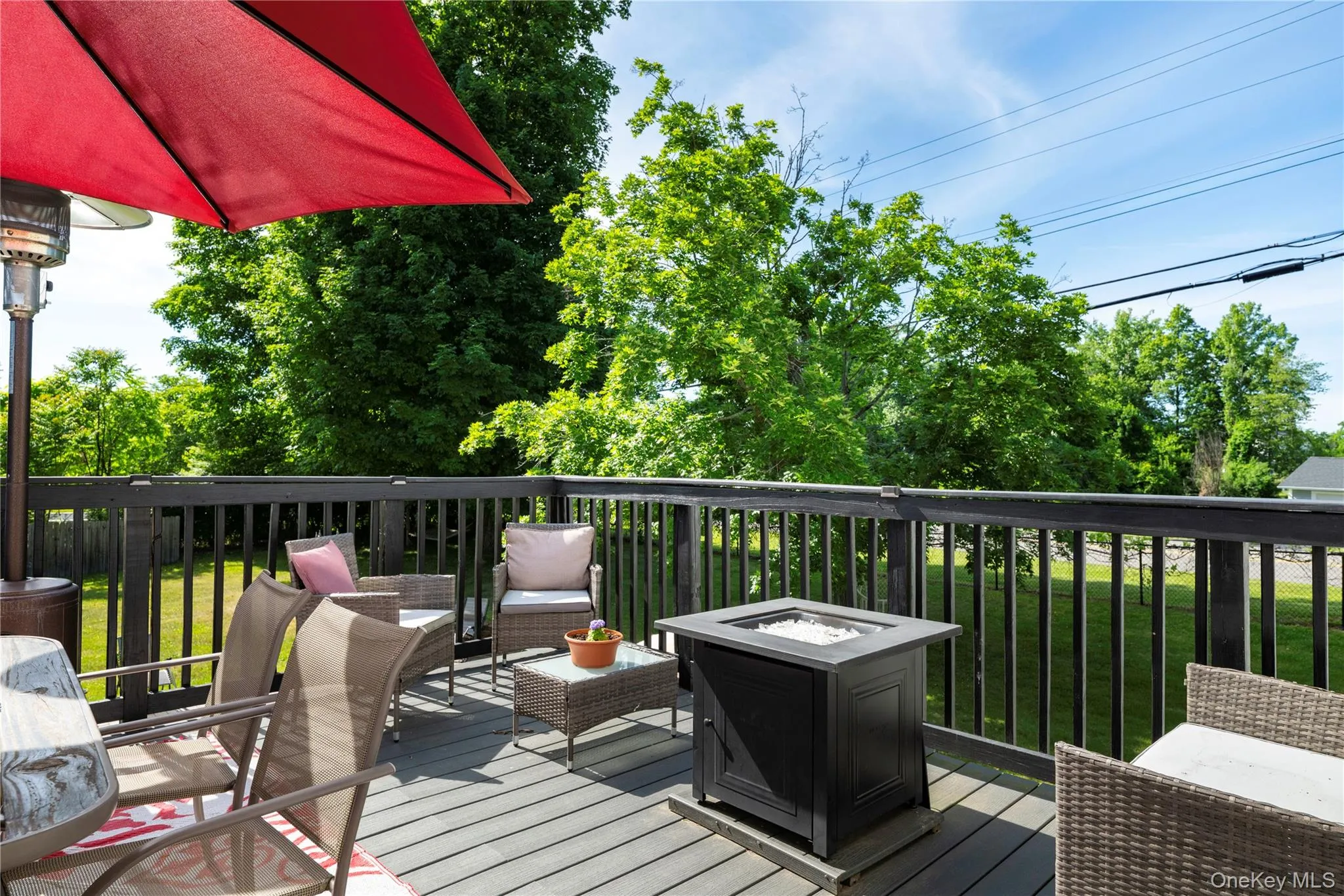 Spacious outdoor deck with dark wood railing and composite decking Spacious outdoor deck with dark wood railing and composite decking