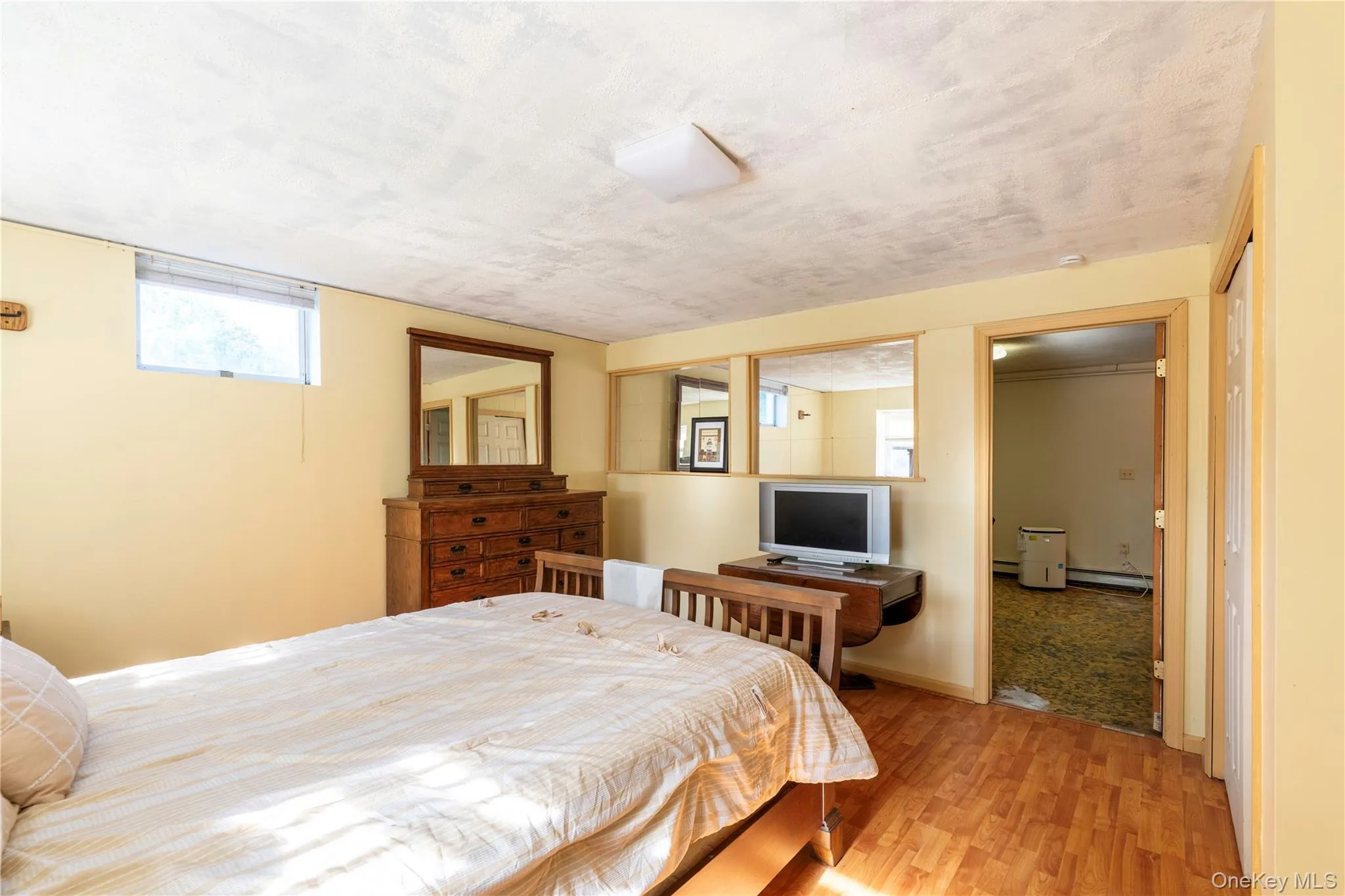 Room featuring wood-finish flooring, light yellow walls, and a recessed window Room featuring wood-finish flooring, light yellow walls, and a recessed window
