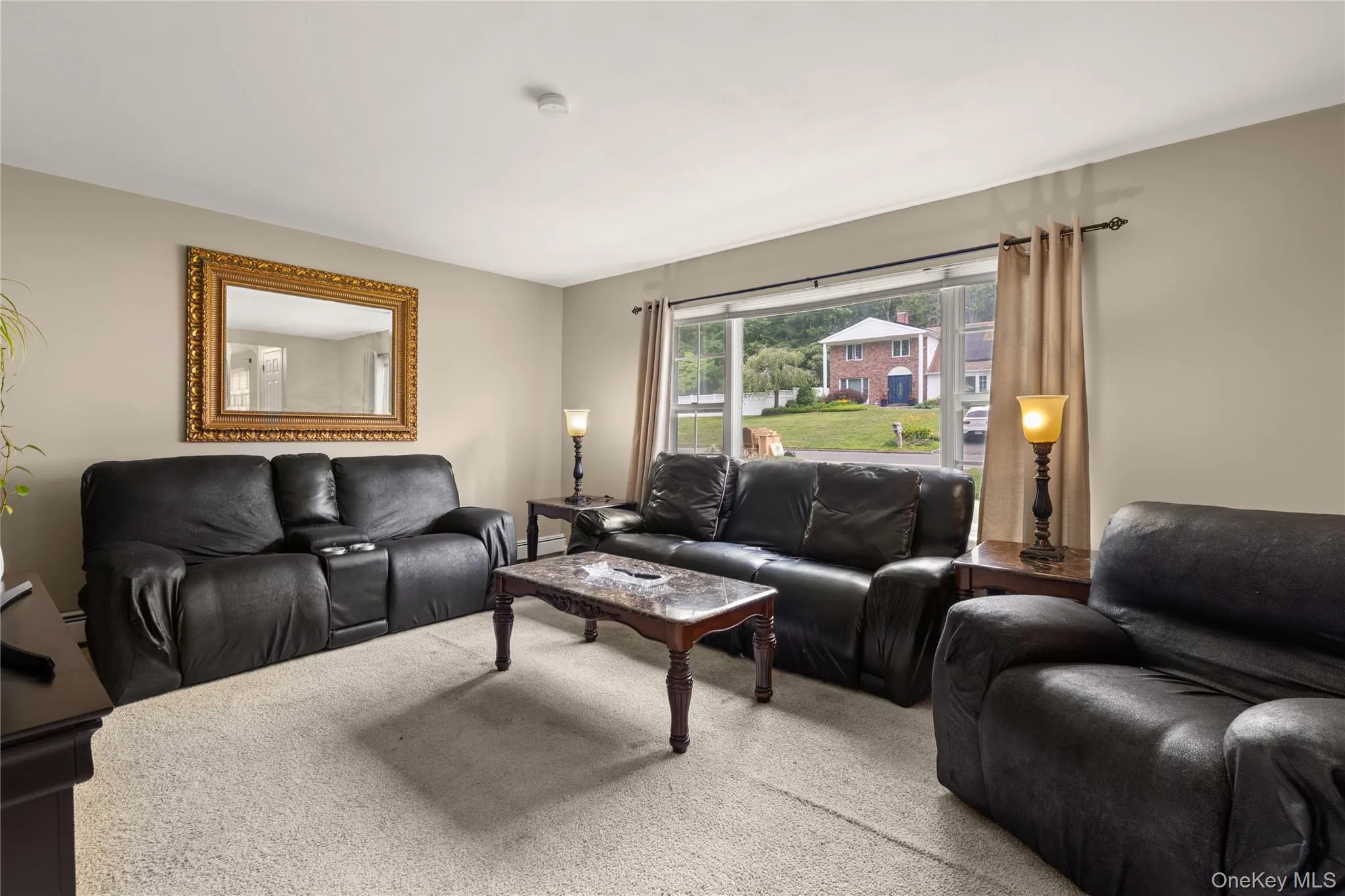 Spacious living area featuring neutral wall tones and light-colored carpeting Spacious living area featuring neutral wall tones and light-colored carpeting