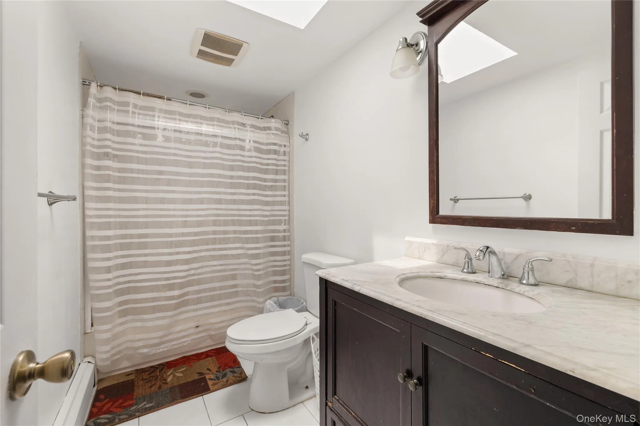 Guest bathroom with skylight, vanity and bathtub Guest bathroom with skylight, vanity and bathtub