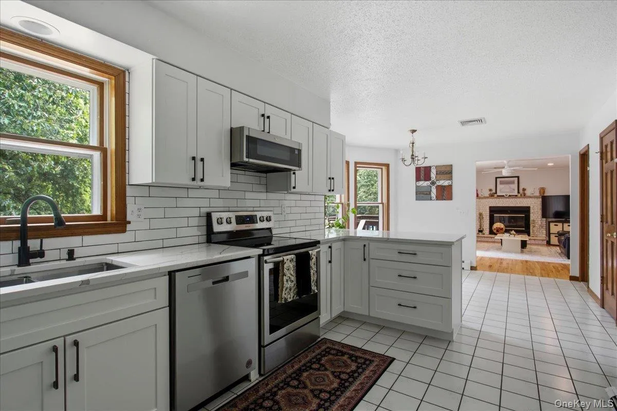 Kitchen featuring white cabinetry, quartz countertops and stainless steel appliances Kitchen featuring white cabinetry, quartz countertops and stainless steel appliances
