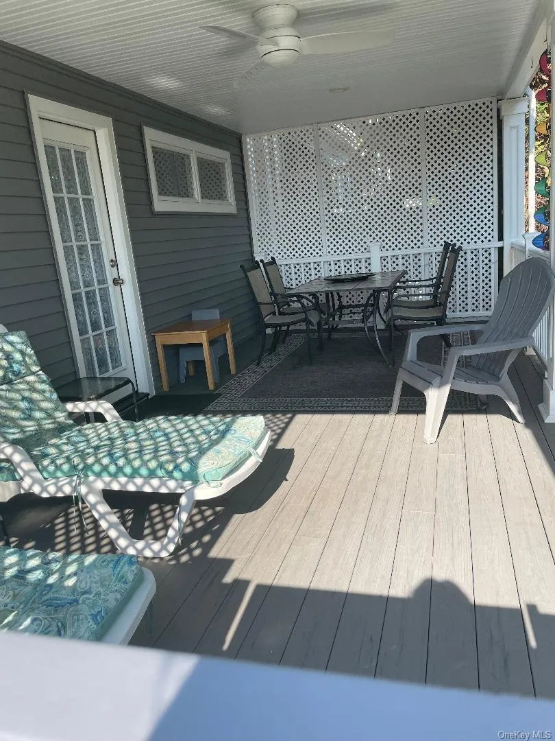 Wooden terrace featuring outdoor dining area and a ceiling fan Wooden terrace featuring outdoor dining area and a ceiling fan