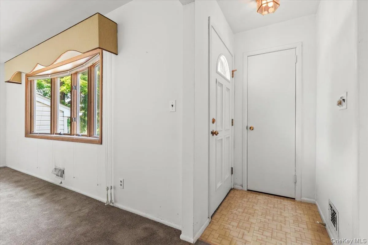 front door / entry way with coat closet (wood floors beneath carpets) front door / entry way with coat closet (wood floors beneath carpets)