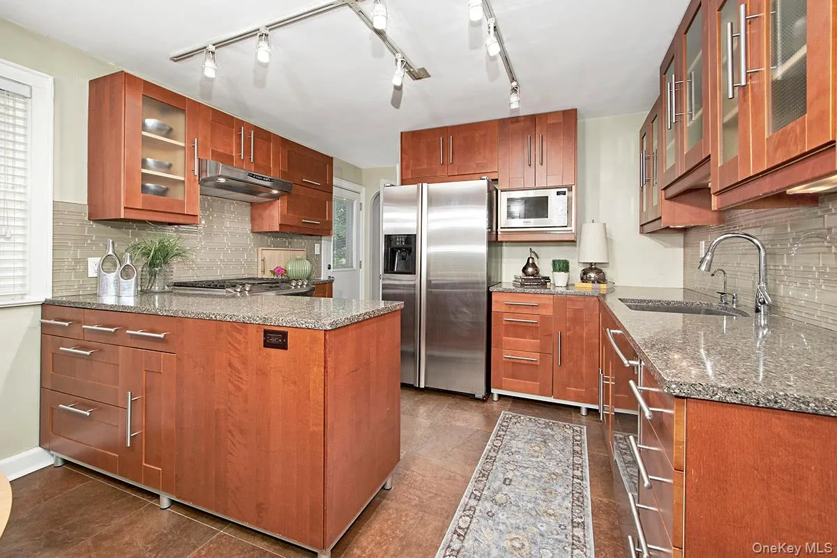 Kitchen work area, granite countertops, glass tile backsplash, stainless steel appliance Kitchen work area, granite countertops, glass tile backsplash, stainless steel appliance