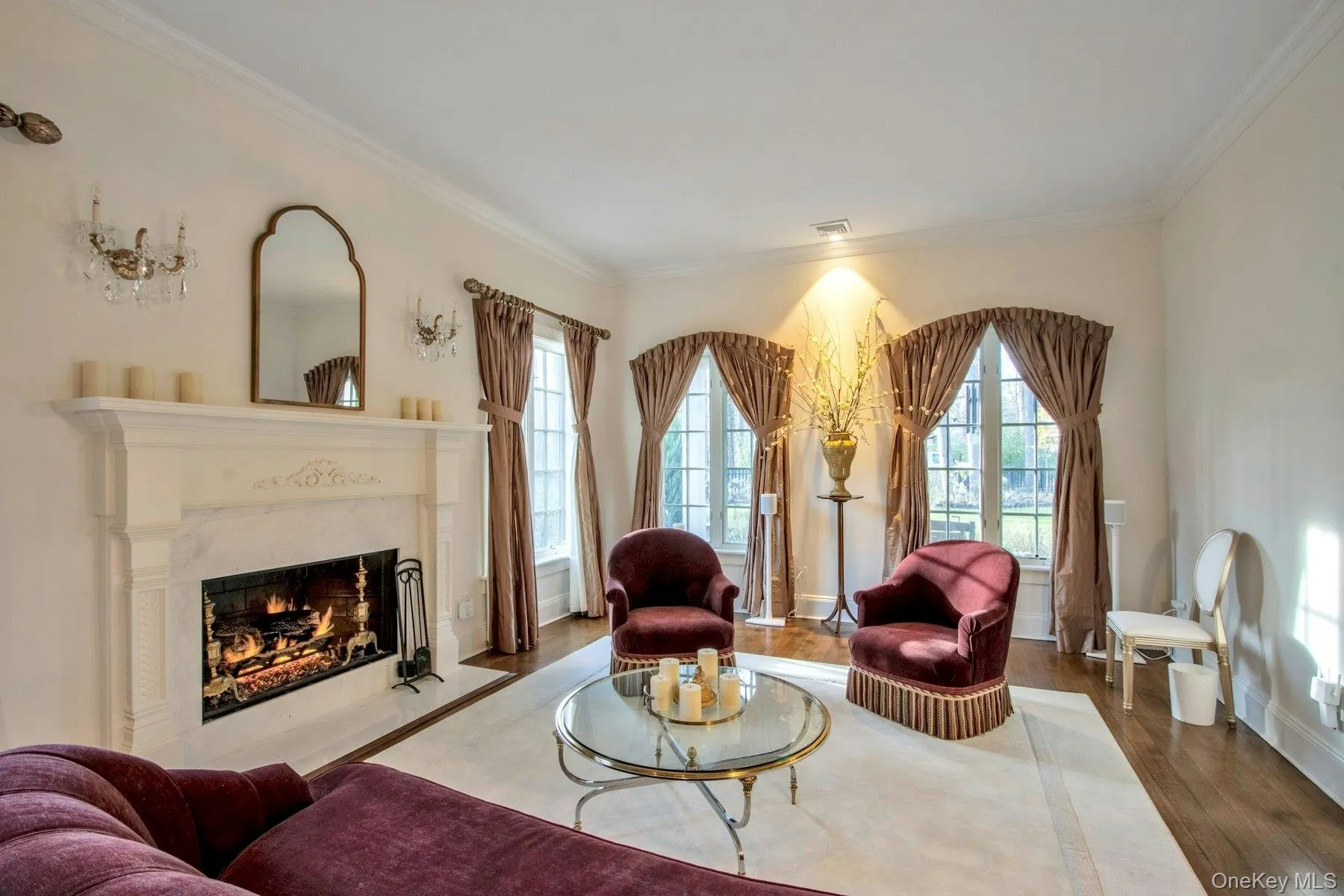 Living room featuring hardwood / wood-style flooring, crown molding, and a high end fireplace Living room featuring hardwood / wood-style flooring, crown molding, and a high end fireplace