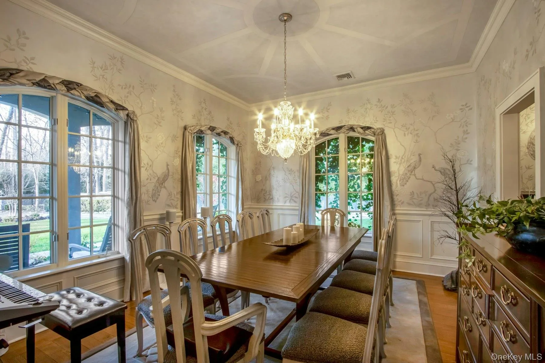 Dining space with a notable chandelier, wood-type flooring, ornamental molding, and a wealth of natural light Dining space with a notable chandelier, wood-type flooring, ornamental molding, and a wealth of natural light