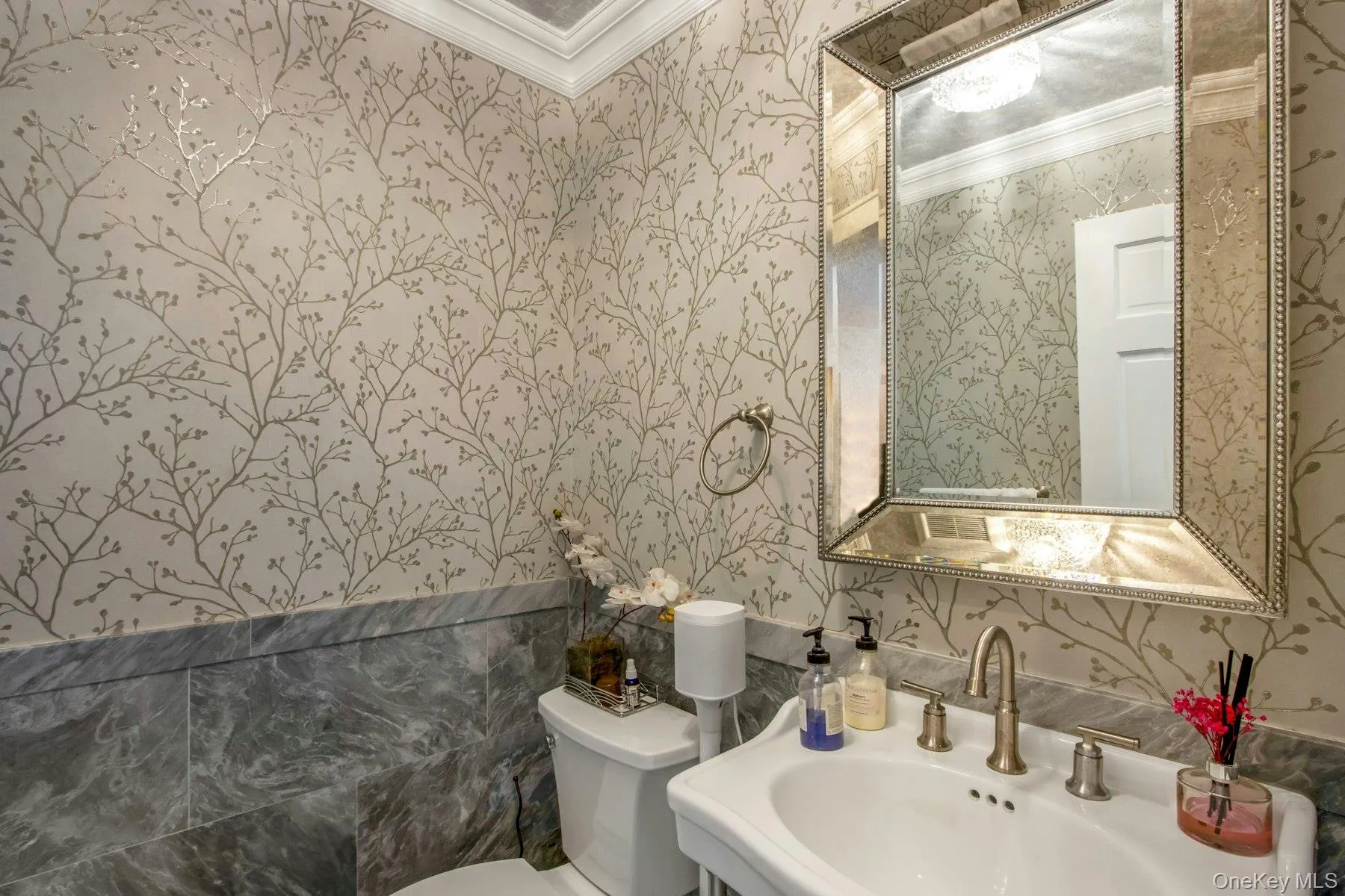Bathroom with crown molding, sink, and toilet Bathroom with crown molding, sink, and toilet