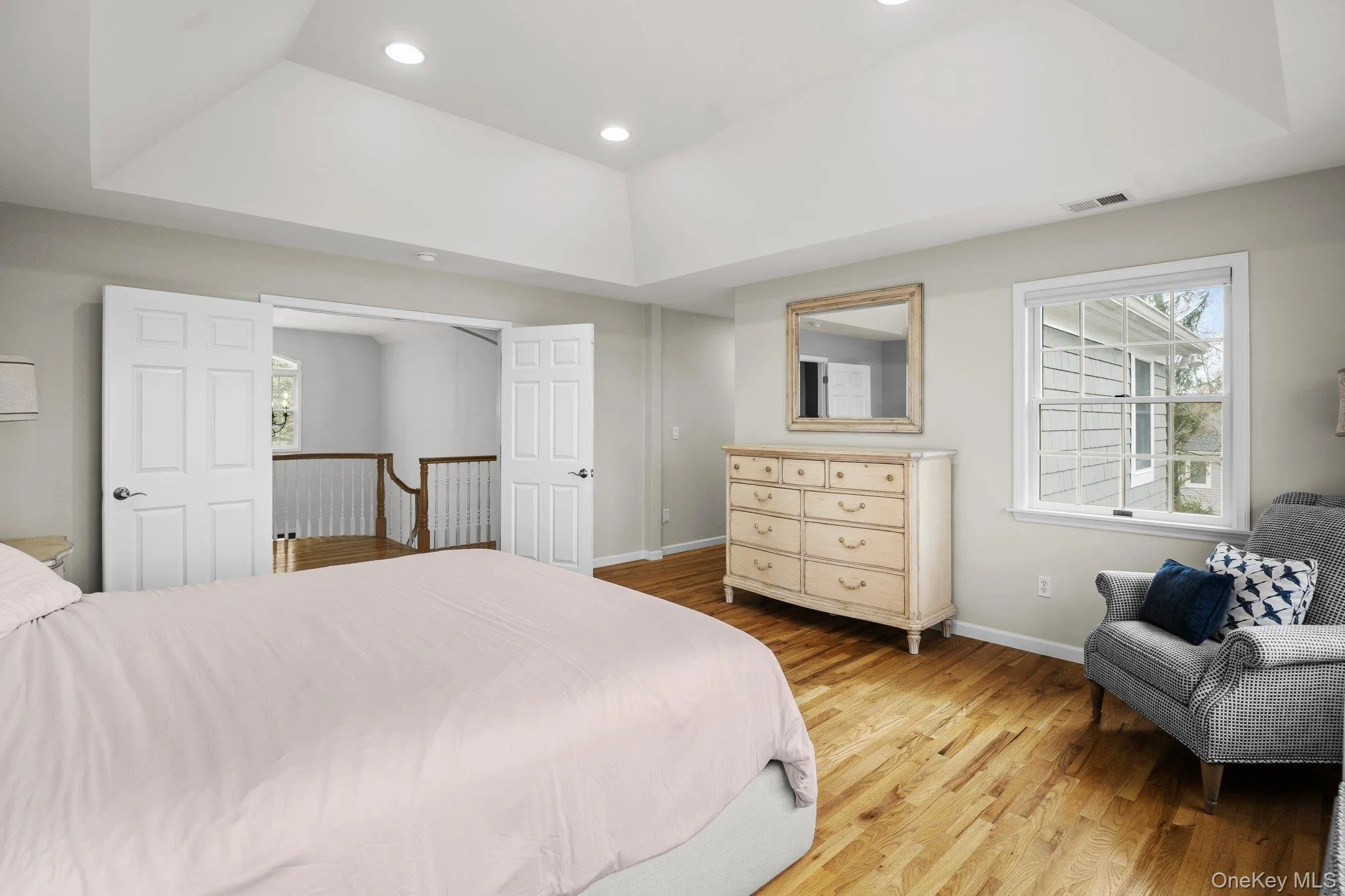 Primary suite featuring double doors and a tray ceiling Primary suite featuring double doors and a tray ceiling