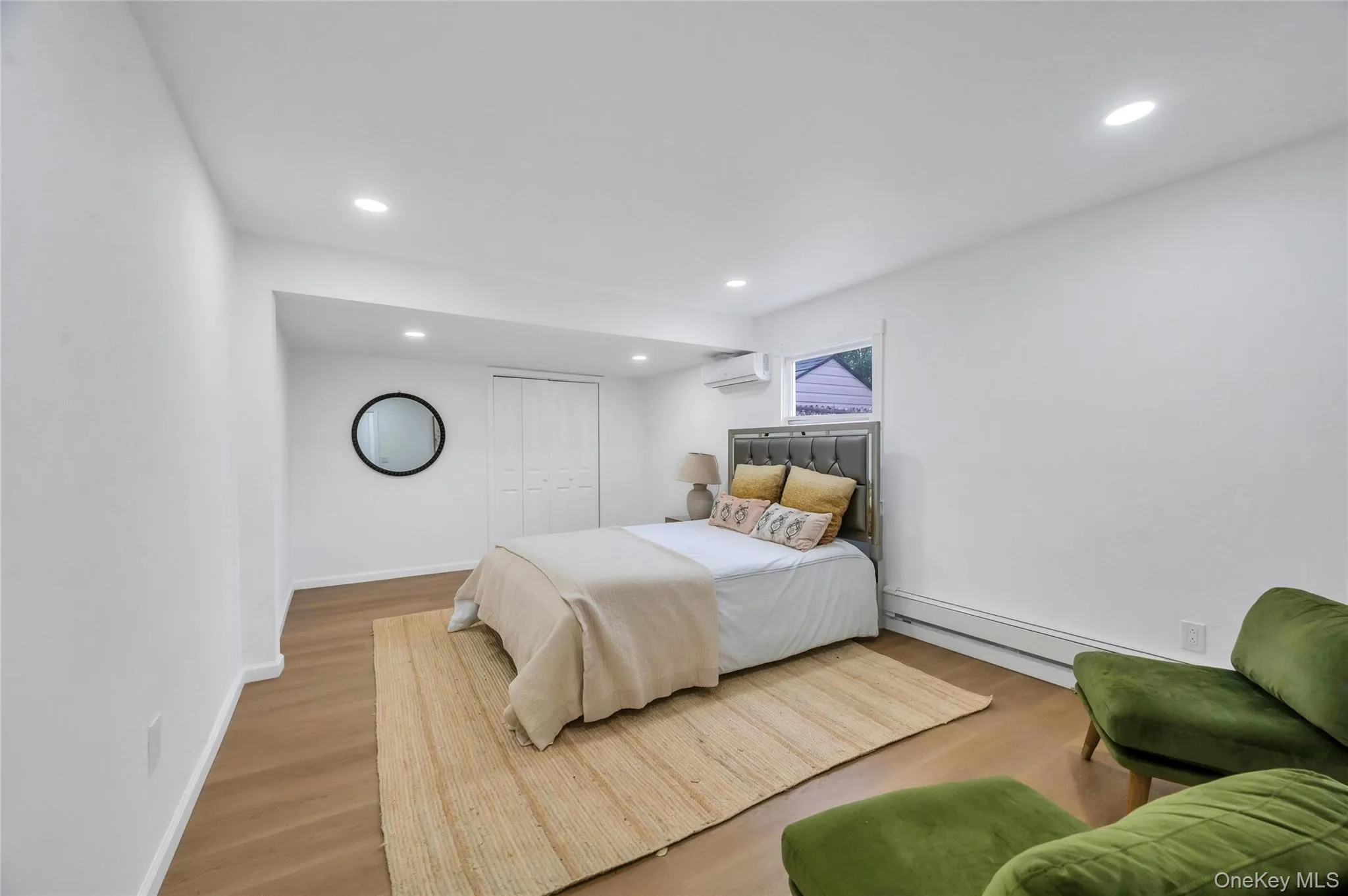 Spacious room featuring wood-finish flooring, recessed lighting, and white walls Spacious room featuring wood-finish flooring, recessed lighting, and white walls