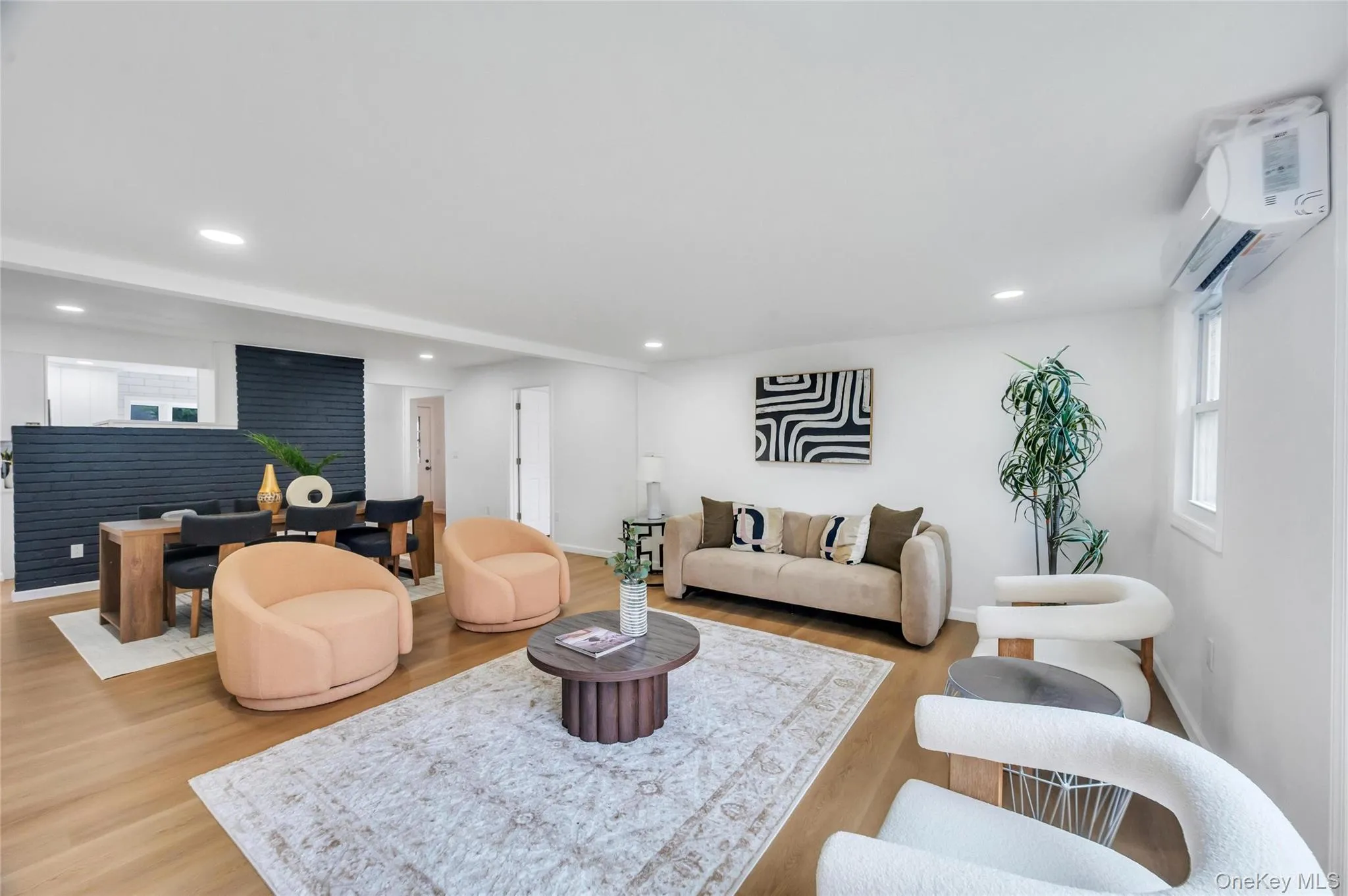 Open-concept living area featuring light wood-finish flooring, recessed lighting, and white walls Open-concept living area featuring light wood-finish flooring, recessed lighting, and white walls